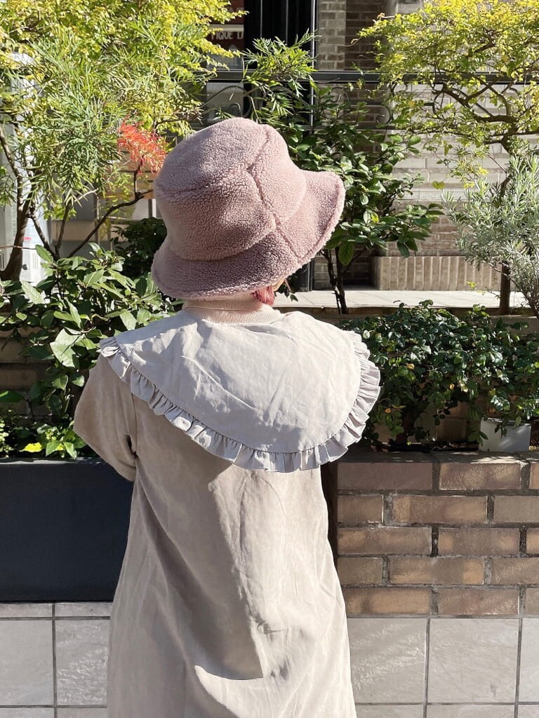 ホワイト系のニット/セーター、ベージュ系のスカート、ホワイト系のブーツを着用したレディースの冬コーディネートの5枚目の写真