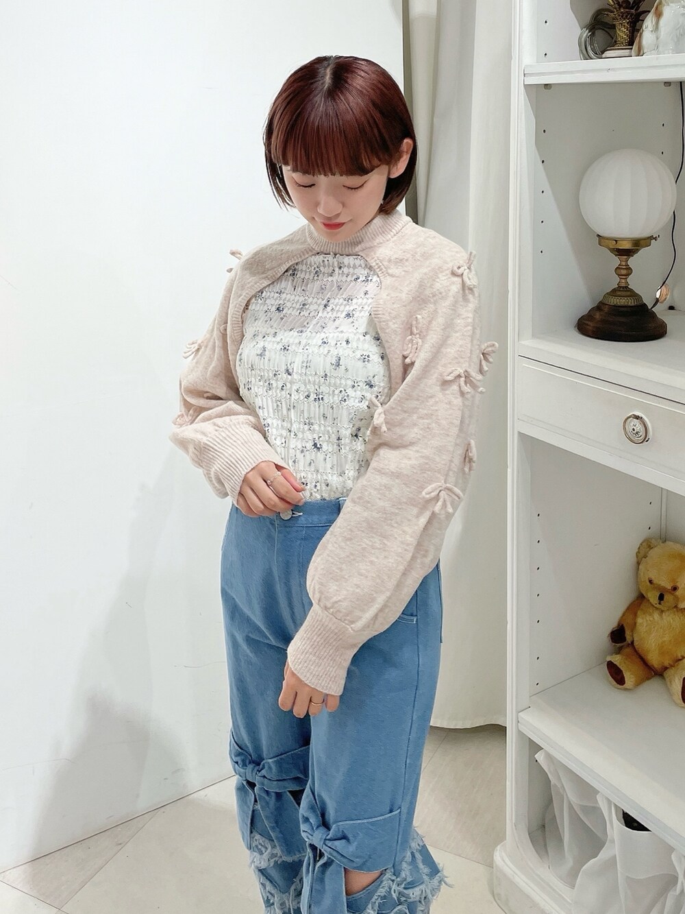 ホワイト系のTシャツ/カットソー、ピンク系のカーディガン/ボレロ、ブルー系のデニムパンツを着用したレディースの春コーディネートの3枚目の写真