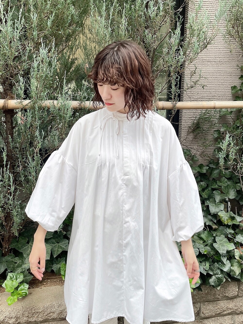 ホワイト系のワンピース、ホワイト系のスラックス、ベージュ系のブーツを着用したレディースの冬コーディネートの5枚目の写真