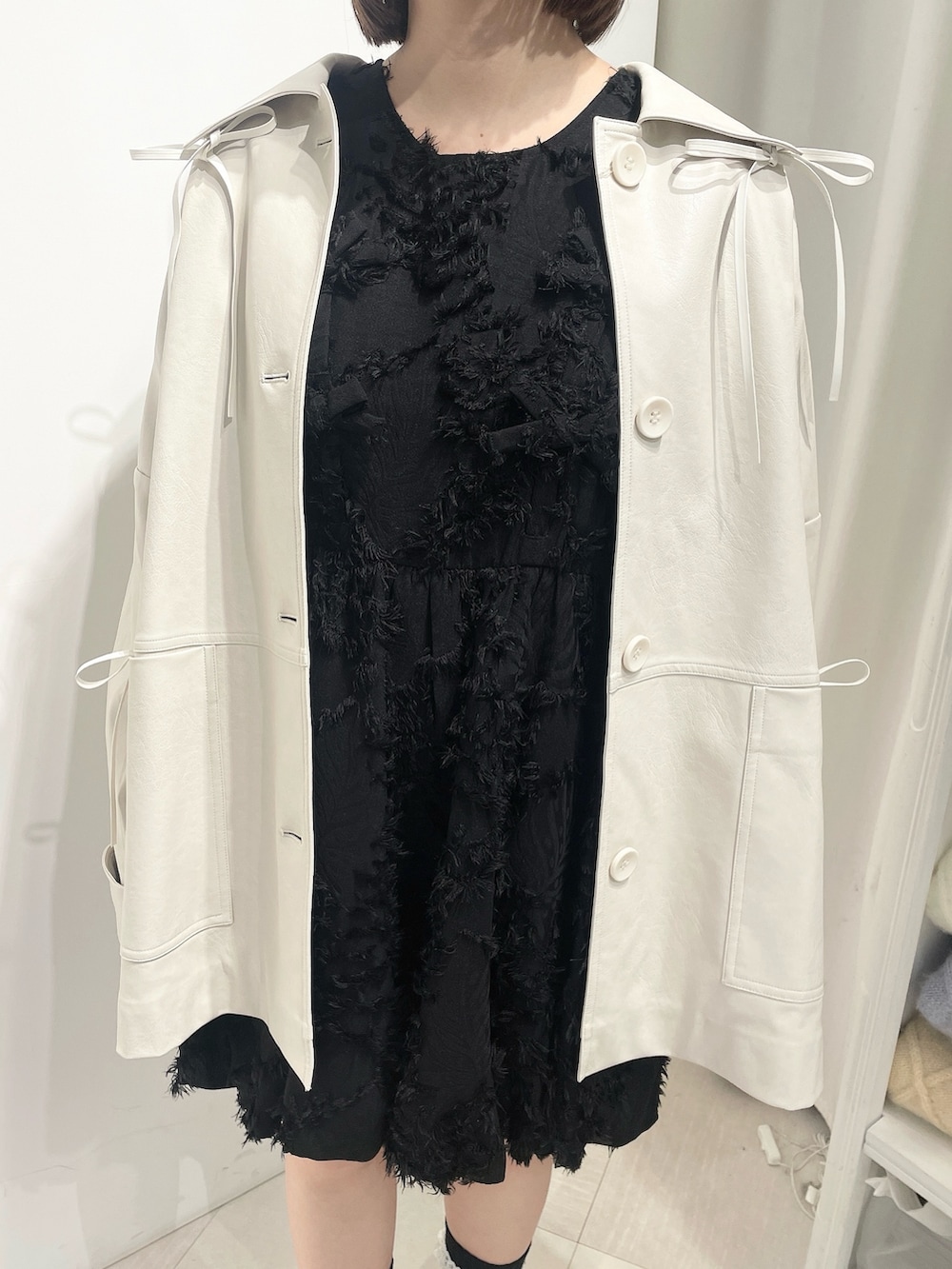 ホワイト系のブルゾン、ブラック系のワンピース、ホワイト系のローファーを着用したレディースの秋コーディネートの5枚目の写真