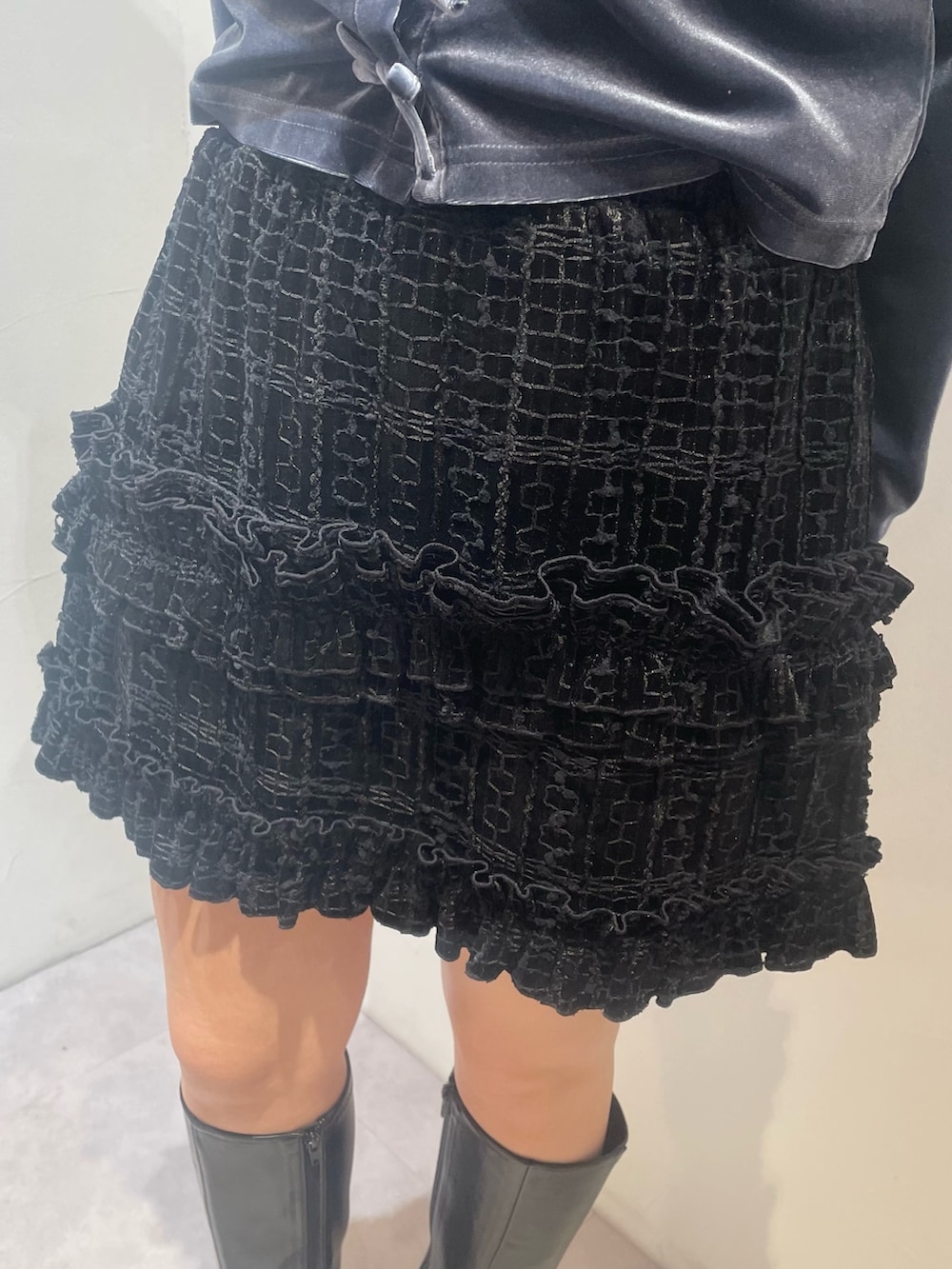 ブラック系のスカート、ブルー系のカーディガン/ボレロ、ブラック系のブーツを着用したレディースの冬コーディネートの6枚目の写真