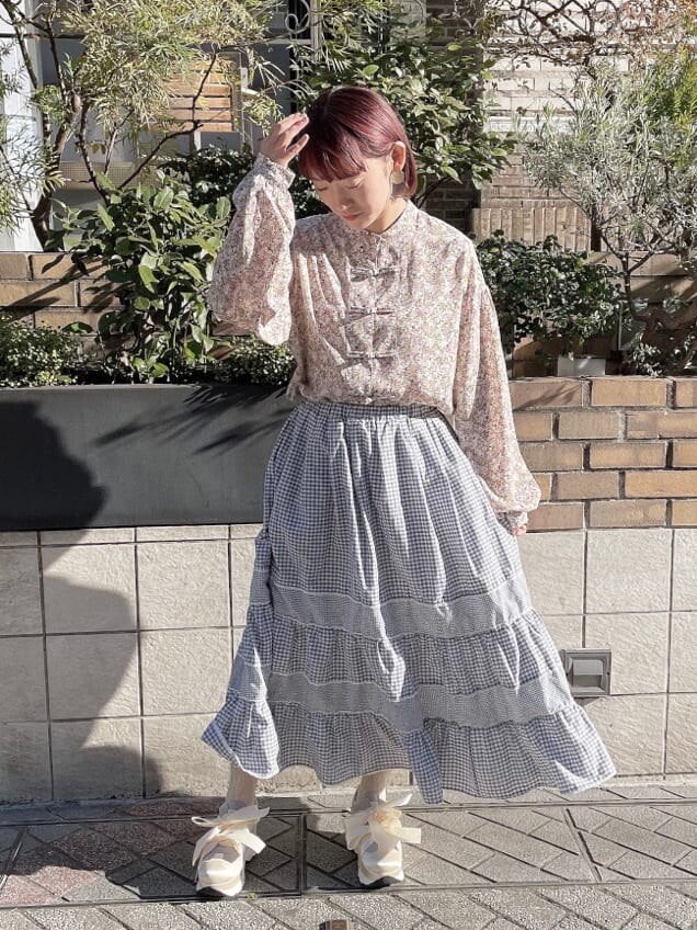 ホワイト系のトレンチコート、オレンジ系のシャツ/ブラウス、ブルー系のスカートを着用したレディースの冬コーディネートの7枚目の写真