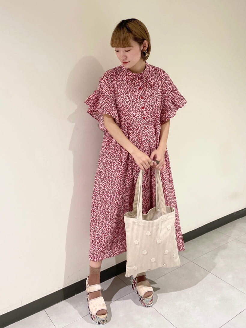 レッド系のワンピース、ベージュ系のサンダル、ホワイト系のトートバッグを着用したレディースの夏コーディネートの2枚目の写真