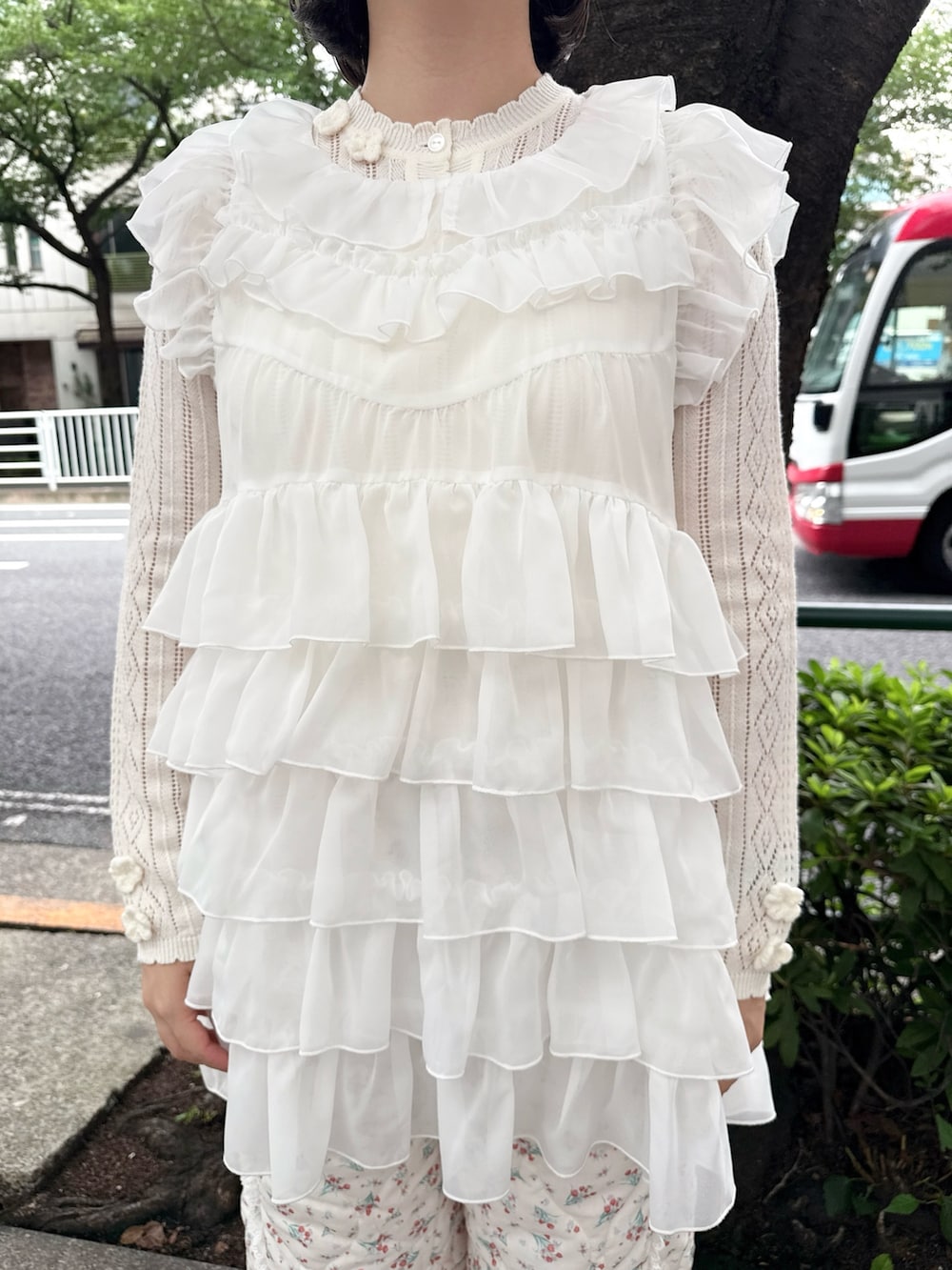 ホワイト系のシャツ/ブラウス、ホワイト系のニット/セーター、ピンク系のハンドバッグを着用したレディースの夏コーディネートの6枚目の写真