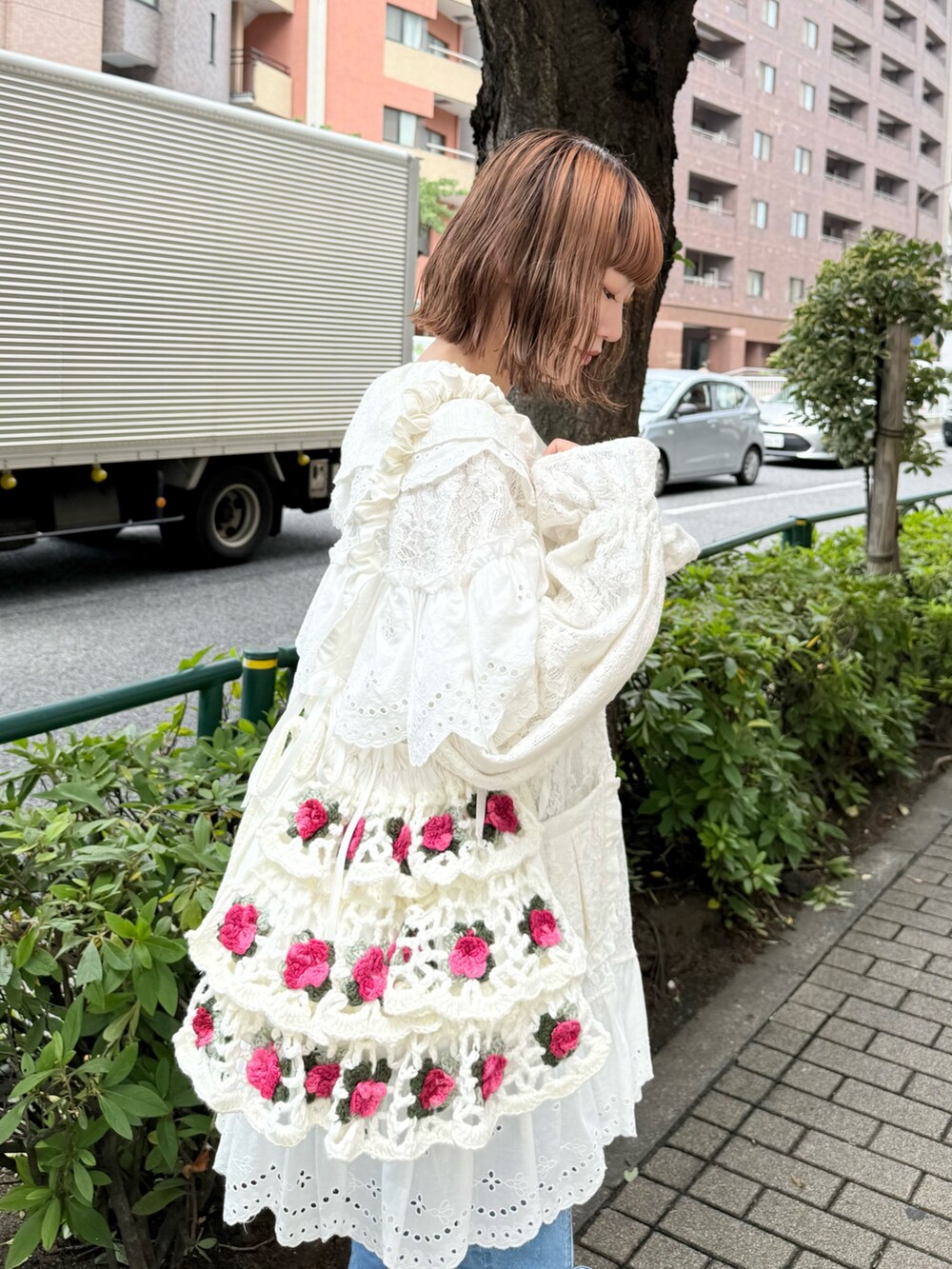 ホワイト系のテーラードジャケット、ブルー系のデニムパンツ、ホワイト系のショルダーバッグを着用したレディースの夏コーディネートの6枚目の写真