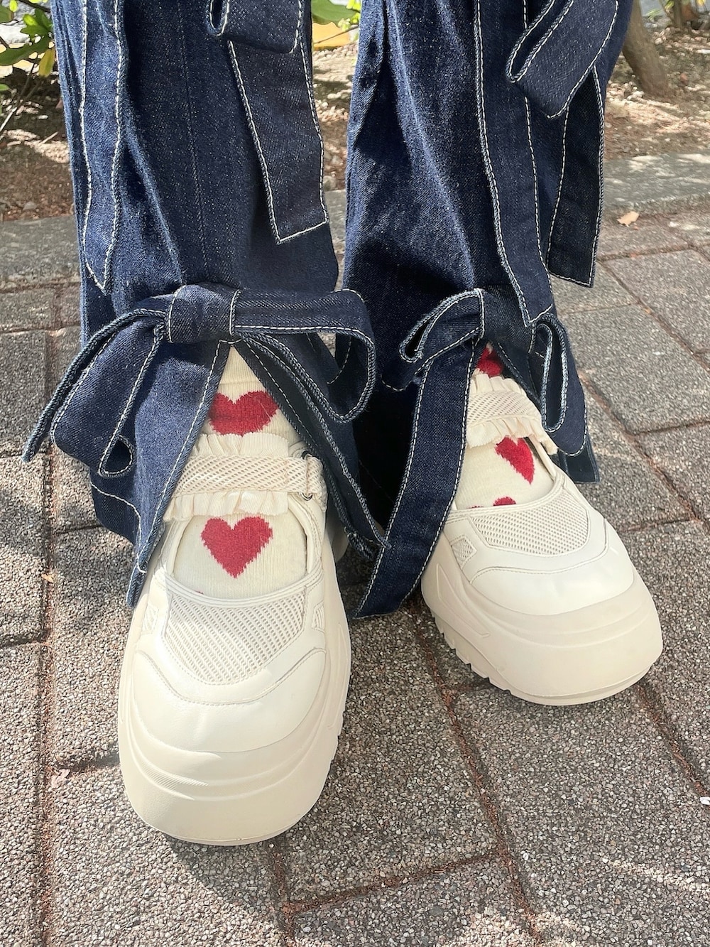 ホワイト系のハンドバッグ、ホワイト系のニット/セーター、ブルー系のカーディガン/ボレロを着用したレディースの冬コーディネートの5枚目の写真