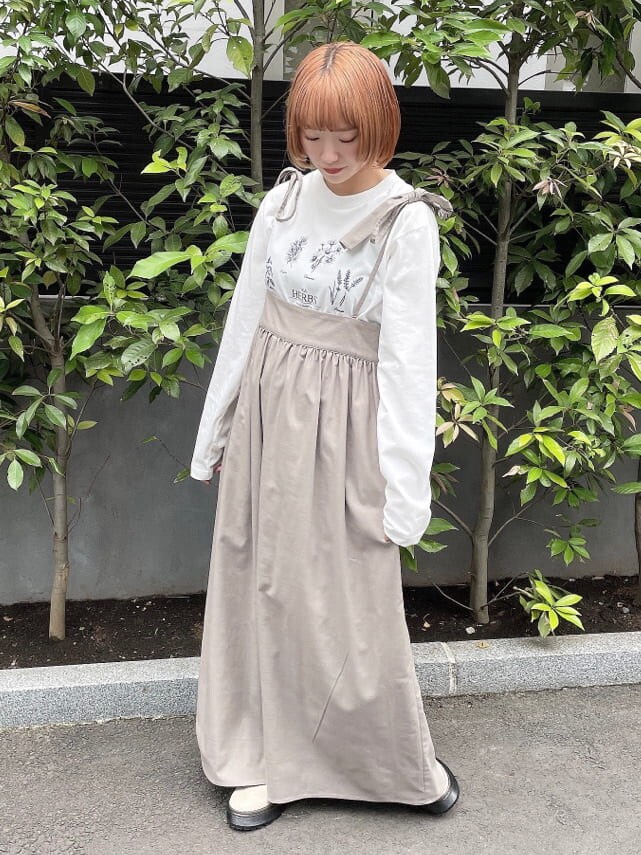 ホワイト系のブーツ、ブラウン系のスカート、ホワイト系のTシャツ/カットソーを着用したレディースの秋コーディネートの2枚目の写真