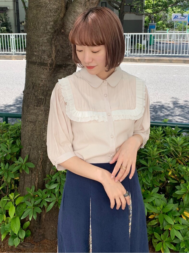 ホワイト系のパンプス、ベージュ系のシャツ/ブラウス、ブルー系のスカートを着用したレディースの春コーディネートの4枚目の写真