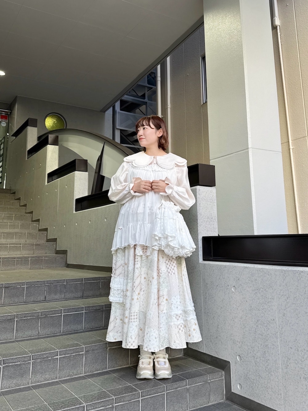 ピンク系のシャツ/ブラウス、ホワイト系のスカート、ホワイト系のチュニックを着用したレディースの春コーディネートの2枚目の写真