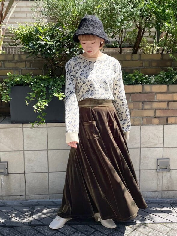 ホワイト系のニット/セーター、ホワイト系のその他シューズ、ベージュ系のスカートを着用したレディースの秋コーディネートの2枚目の写真