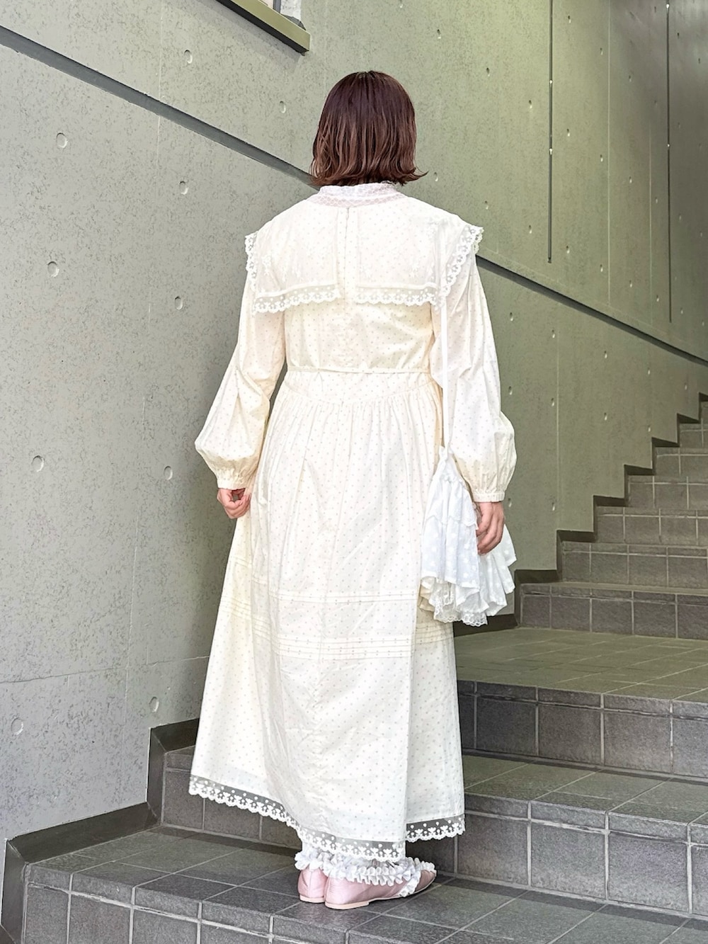 ベージュ系のワンピース、ピンク系のTシャツ/カットソー、ホワイト系のショルダーバッグを着用したレディースの春コーディネートの3枚目の写真