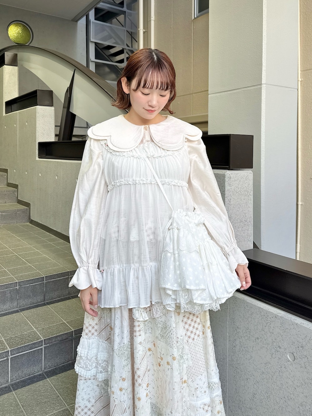 ピンク系のシャツ/ブラウス、ホワイト系のスカート、ホワイト系のショルダーバッグを着用したレディースの春コーディネートの4枚目の写真