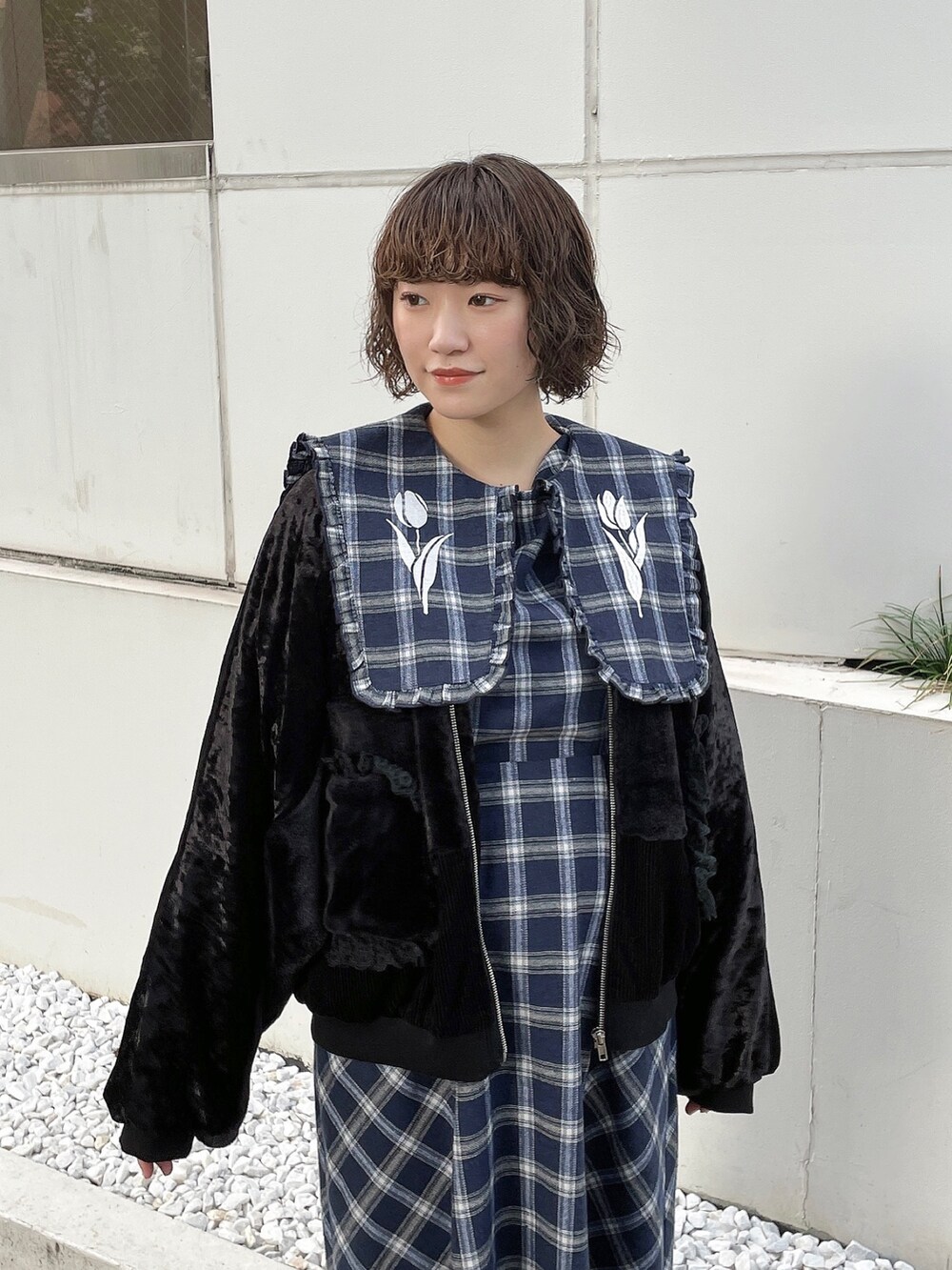 ブルー系のワンピース、ブラック系のブルゾン、ブラック系のスニーカーを着用したレディースの秋コーディネートの5枚目の写真