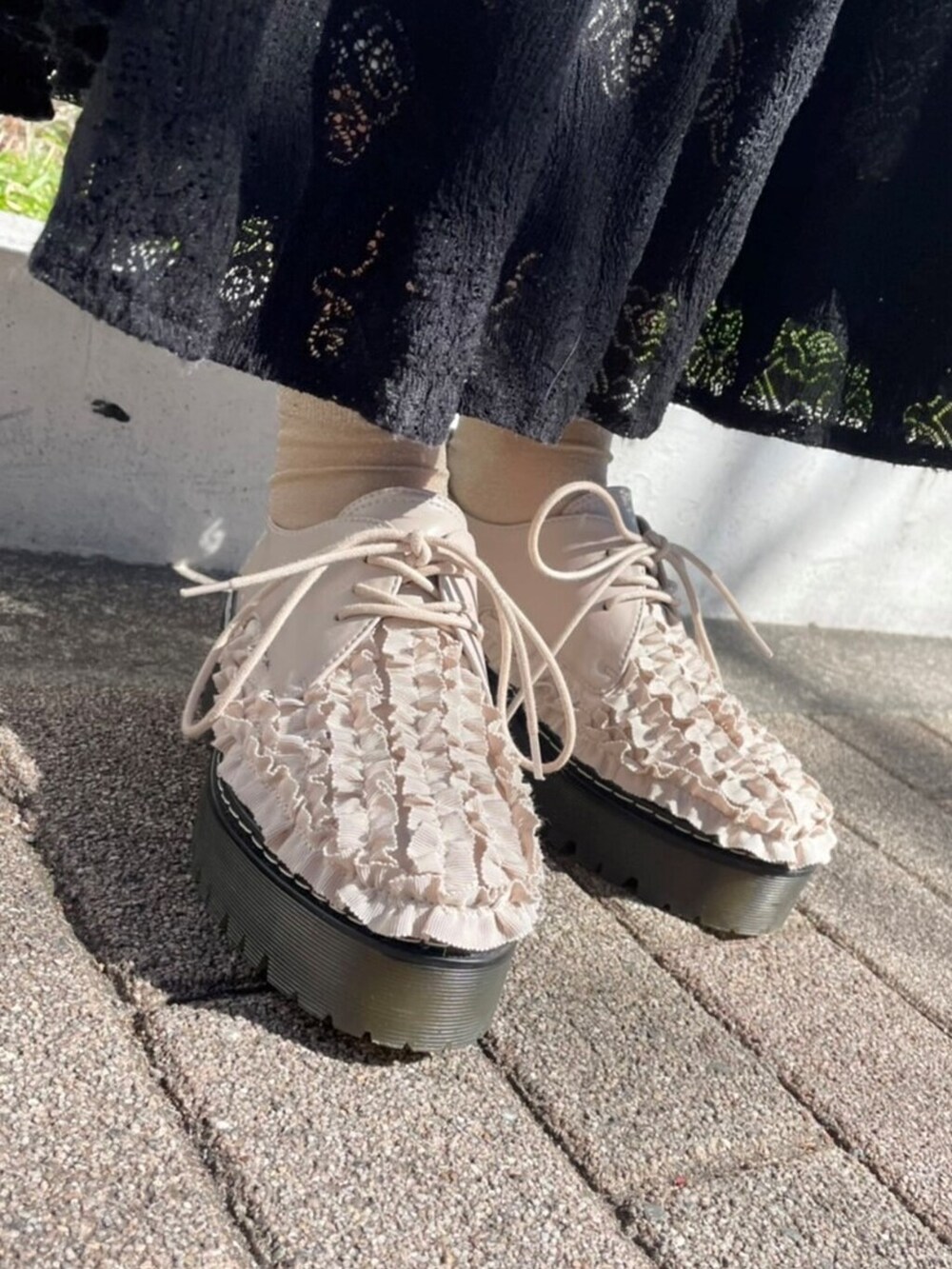 ホワイト系のその他シューズ、ブラック系のスカート、ブラック系のトートバッグを着用したレディースの春コーディネートの5枚目の写真