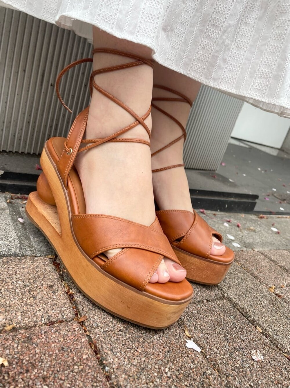 ホワイト系のワンピース、ブラウン系のサンダル、ホワイト系のトートバッグを着用したレディースの春コーディネートの7枚目の写真