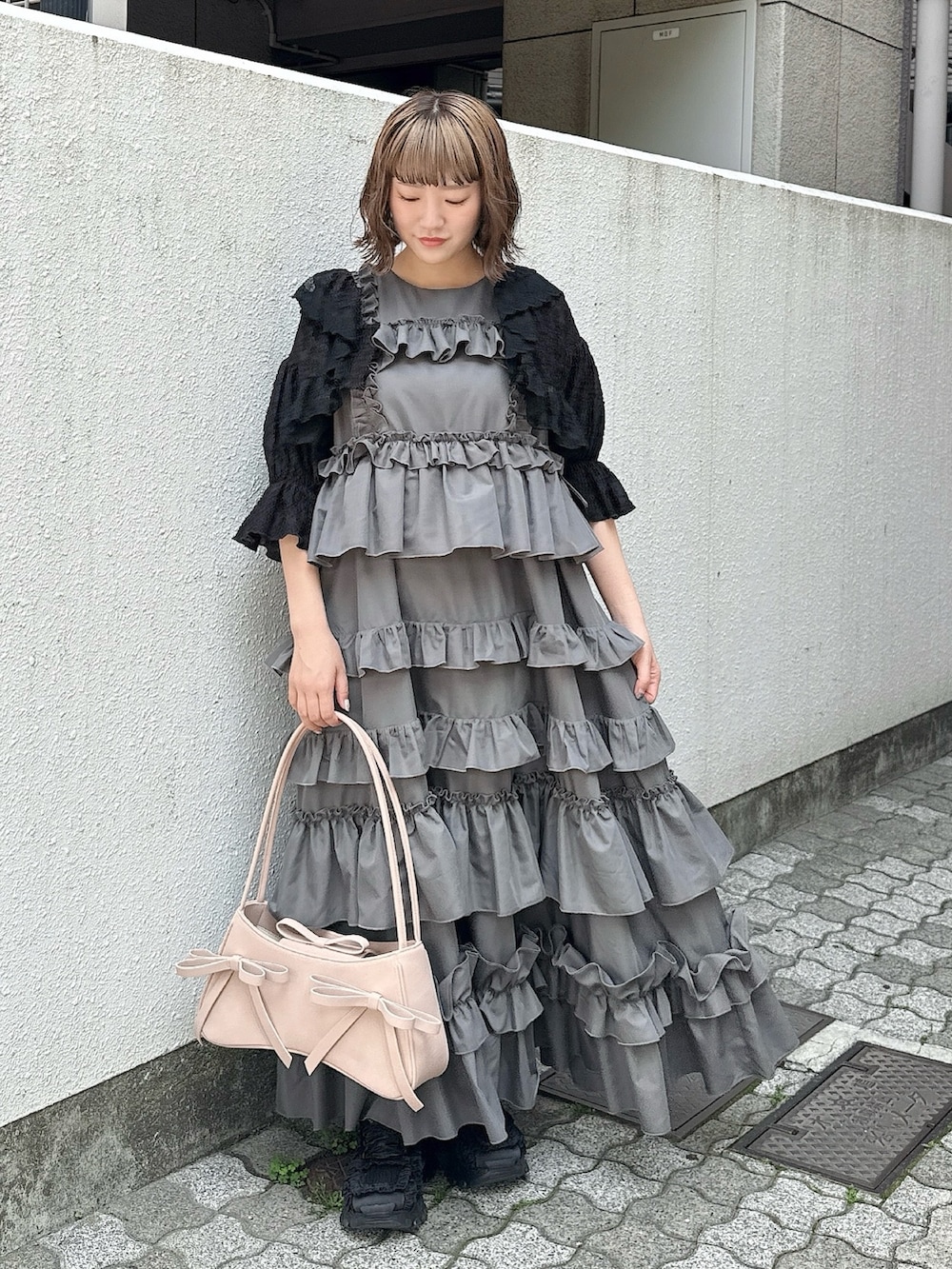 グレー系のワンピース、ブラック系のカーディガン/ボレロ、ピンク系のハンドバッグを着用したレディースの春コーディネートの3枚目の写真