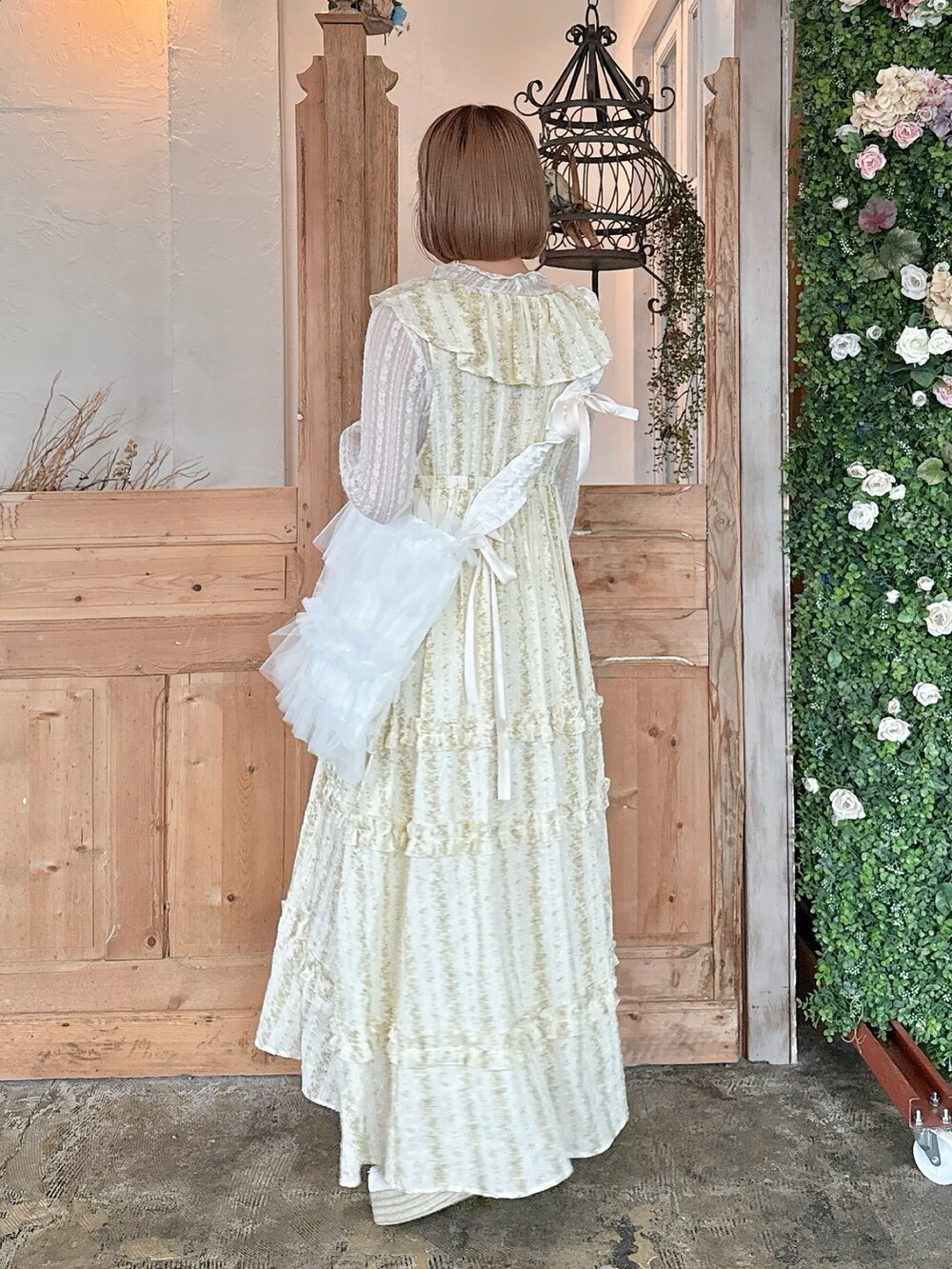 イエロー系のワンピース、ホワイト系のTシャツ/カットソー、ホワイト系のトートバッグを着用したレディースの春コーディネートの3枚目の写真