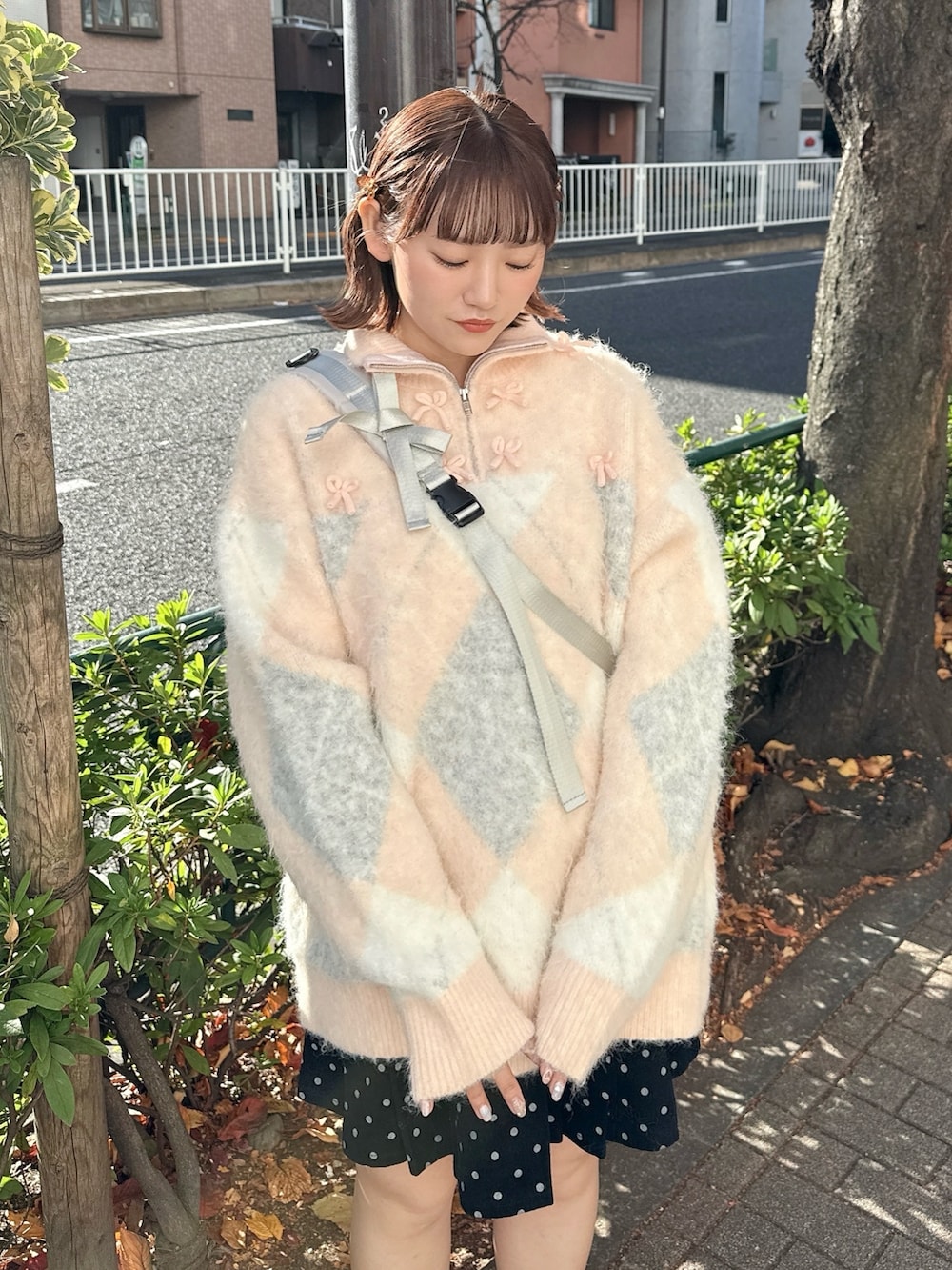 ピンク系のニット/セーター、グレー系のショルダーバッグ、ブラック系のスカートを着用したレディースの冬コーディネートの4枚目の写真