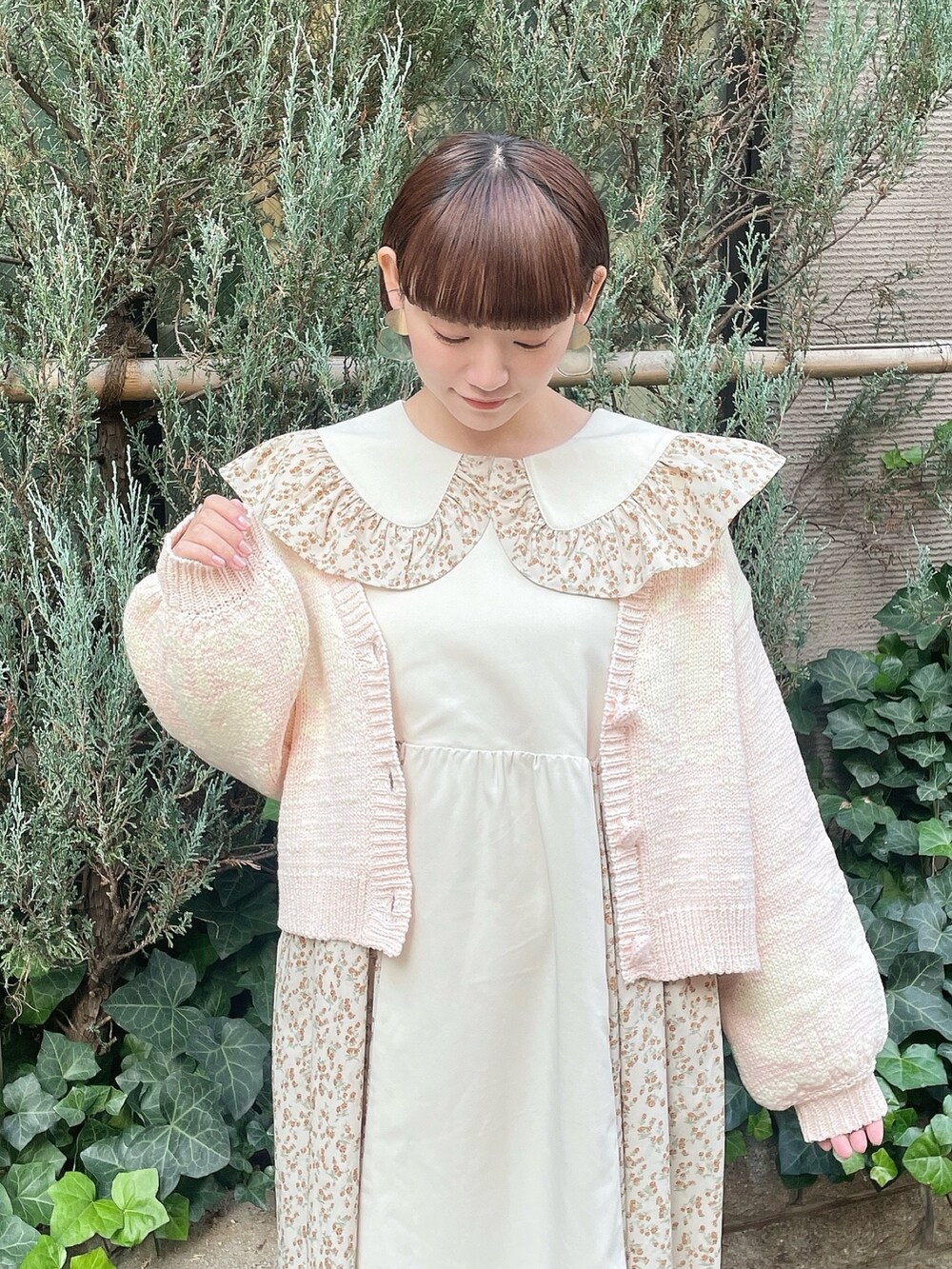 ベージュ系のワンピース、ピンク系のカーディガン/ボレロ、ホワイト系のトートバッグを着用したレディースの冬コーディネートの5枚目の写真