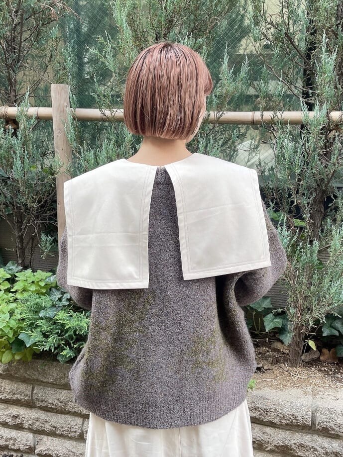 ホワイト系のワンピース、グレー系のカーディガン/ボレロ、ホワイト系のブーツを着用したレディースの秋コーディネートの4枚目の写真