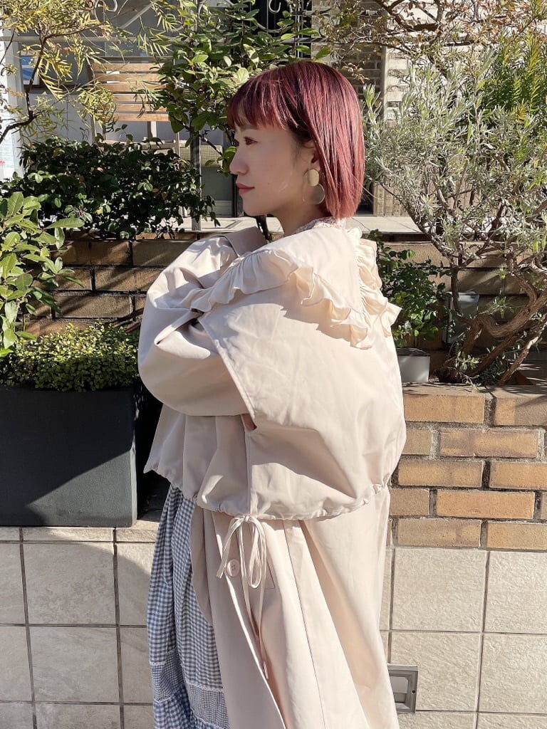 ホワイト系のトレンチコート、オレンジ系のシャツ/ブラウス、ブルー系のスカートを着用したレディースの冬コーディネートの4枚目の写真