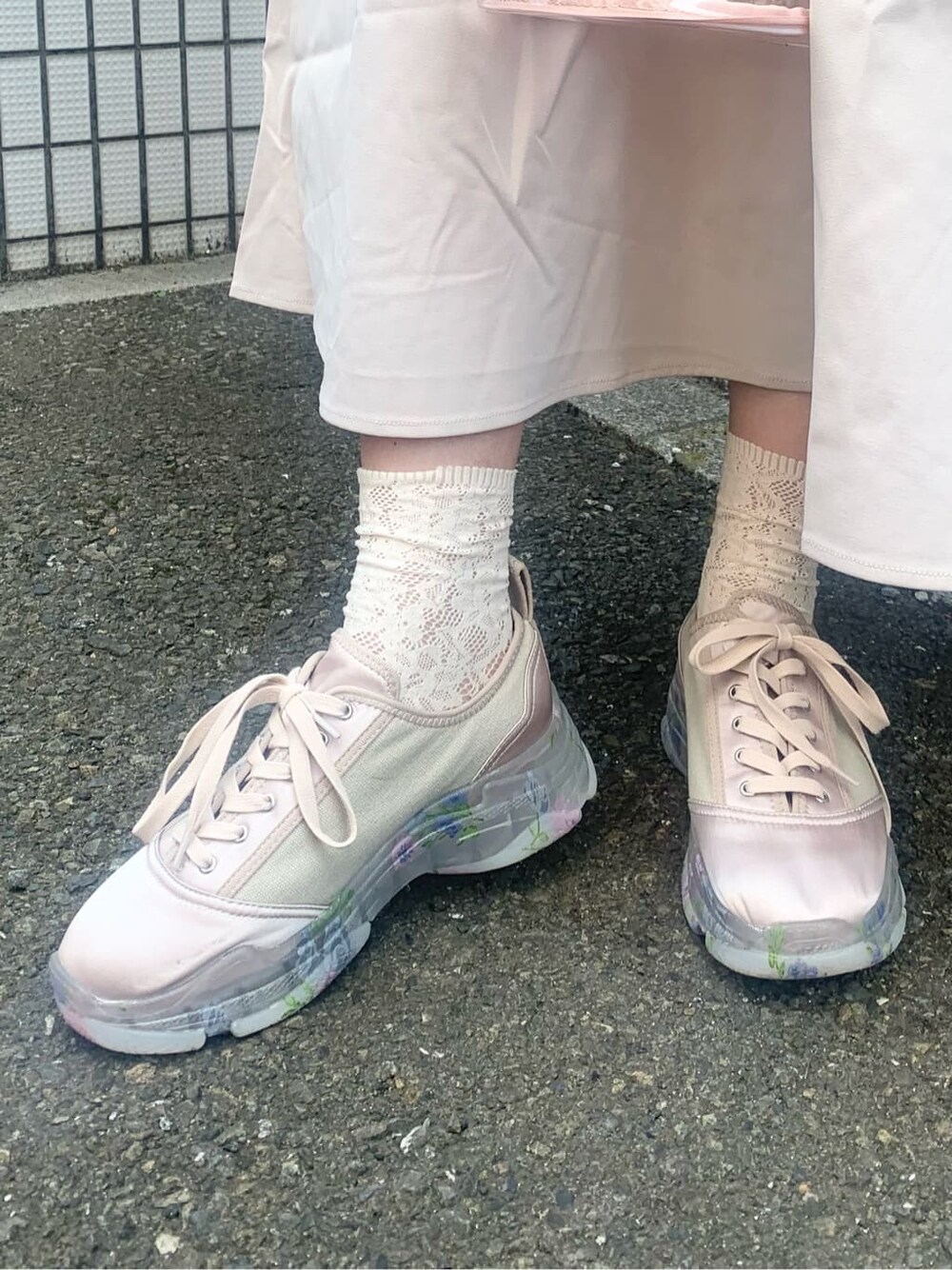 ピンク系のハンドバッグ、ベージュ系のワンピース、ピンク系のスニーカーを着用したレディースの夏コーディネートの6枚目の写真