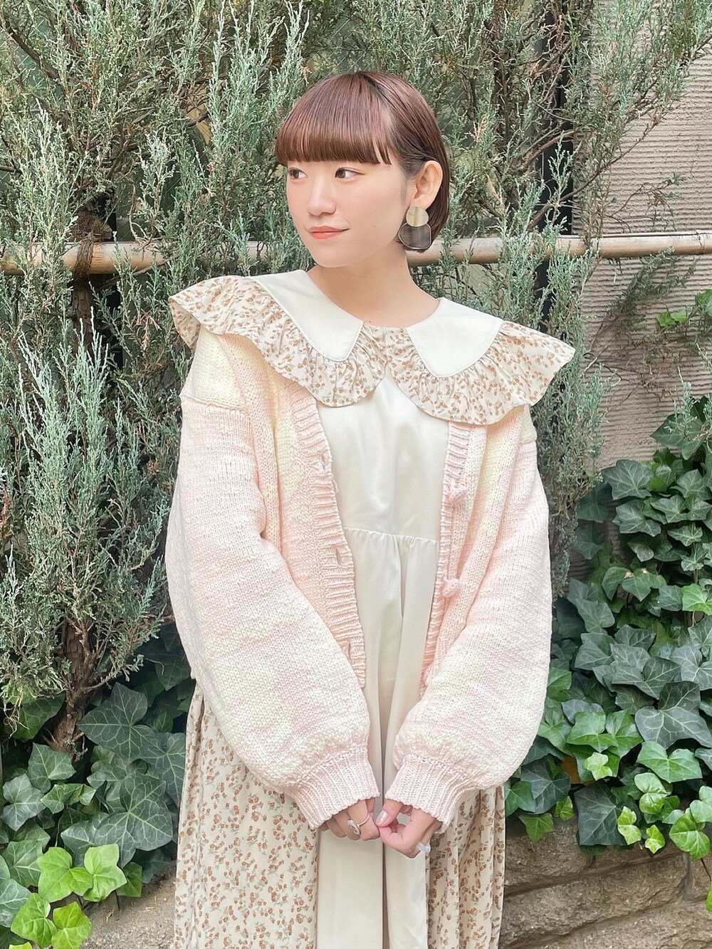 ベージュ系のワンピース、ピンク系のカーディガン/ボレロ、ホワイト系のトートバッグを着用したレディースの冬コーディネートの4枚目の写真