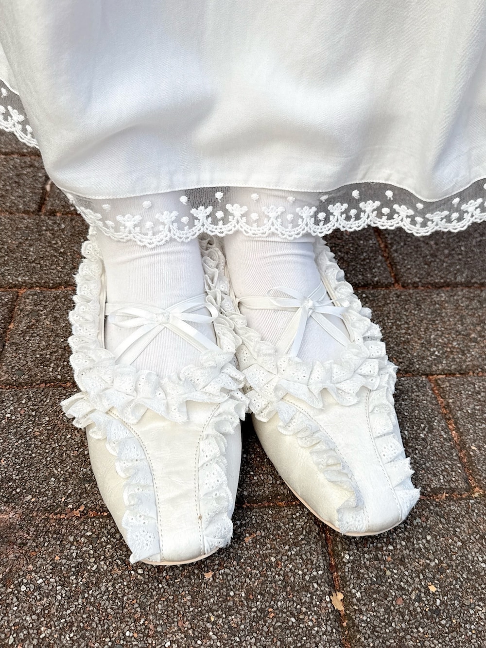 ホワイト系のワンピース、ブルー系のカーディガン/ボレロ、ホワイト系のショルダーバッグを着用したレディースの冬コーディネートの6枚目の写真