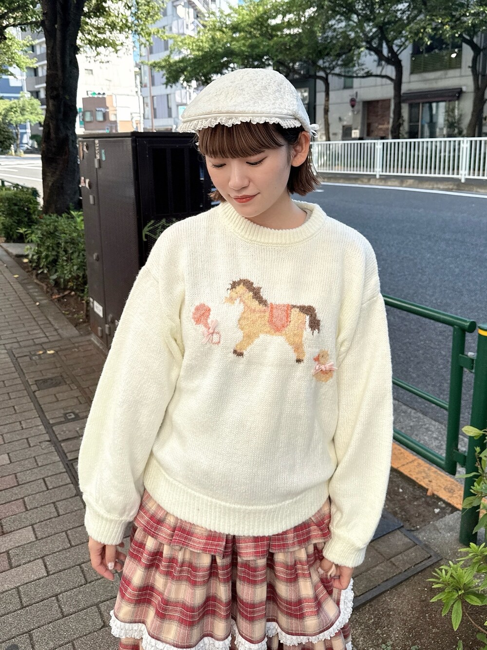 ホワイト系のニット/セーター、ホワイト系のショルダーバッグ、レッド系のスカートを着用したレディースの秋コーディネートの4枚目の写真