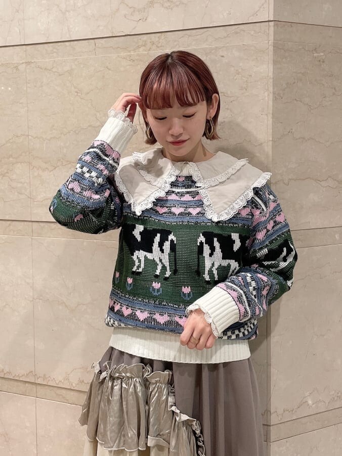 ホワイト系のニット/セーター、ベージュ系のスカート、ホワイト系のブーツを着用したレディースの秋コーディネートの3枚目の写真