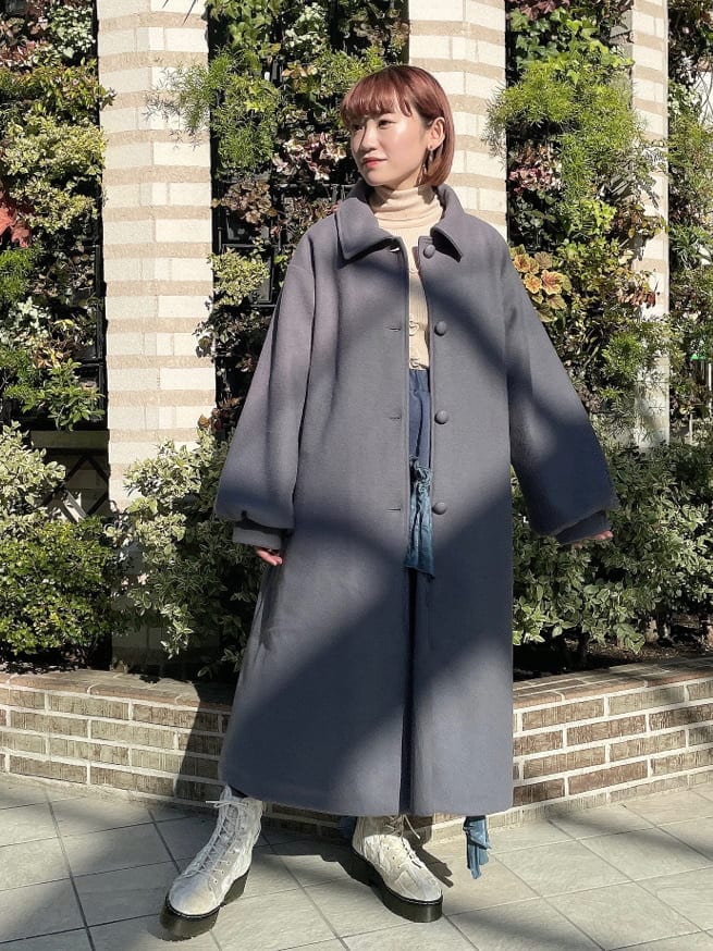 ホワイト系のニット/セーター、ブルー系のステンカラーコート、ブルー系のスカートを着用したレディースの冬コーディネートの4枚目の写真