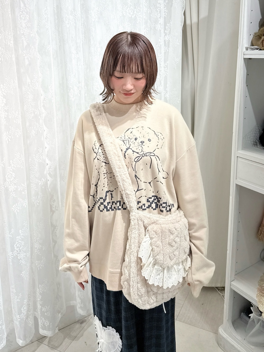 ベージュ系のスウェット、ベージュ系のショルダーバッグ、グリーン系のスカートを着用したレディースの秋コーディネートの5枚目の写真