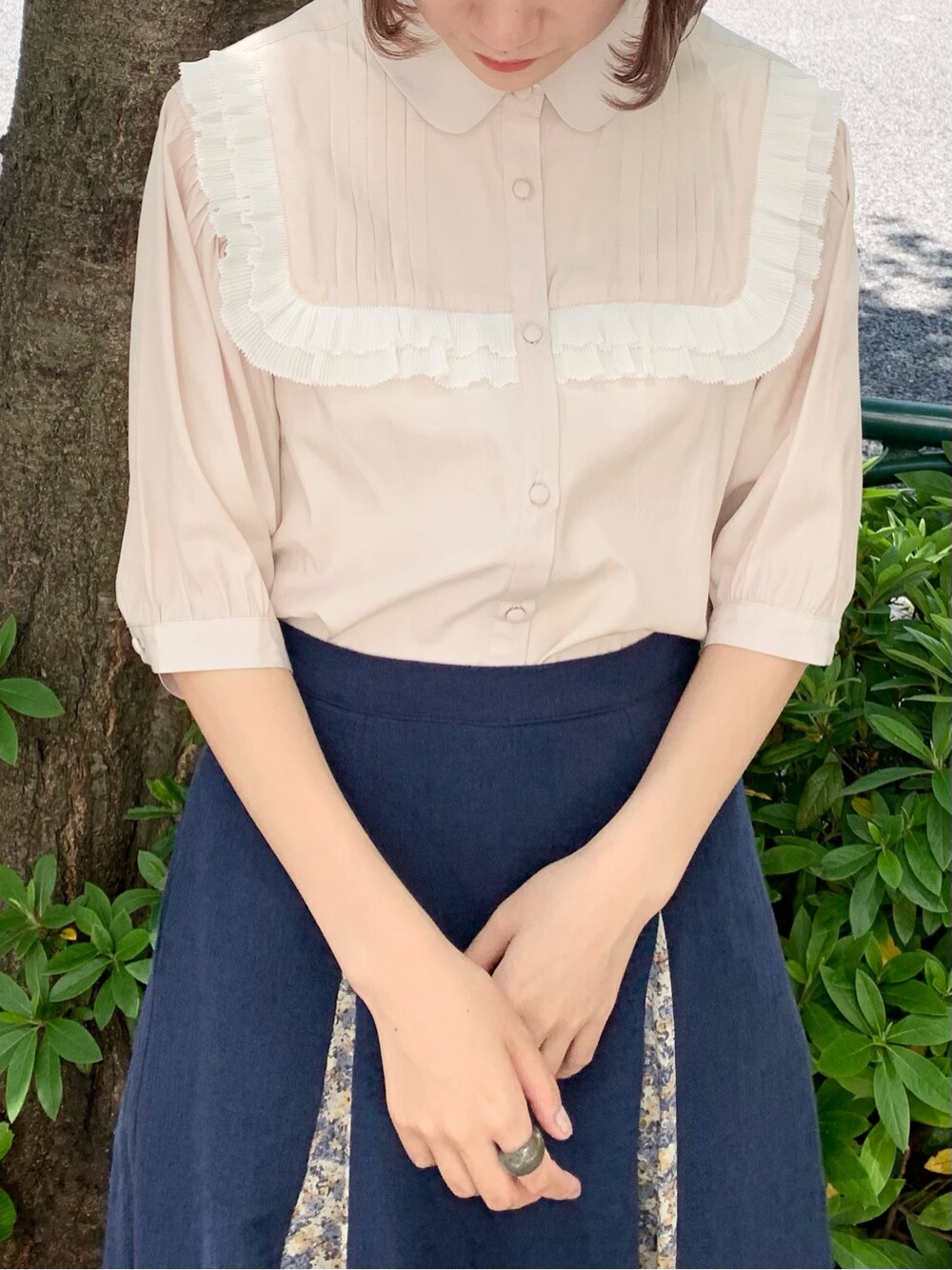 ホワイト系のパンプス、ベージュ系のシャツ/ブラウス、ブルー系のスカートを着用したレディースの春コーディネートの5枚目の写真