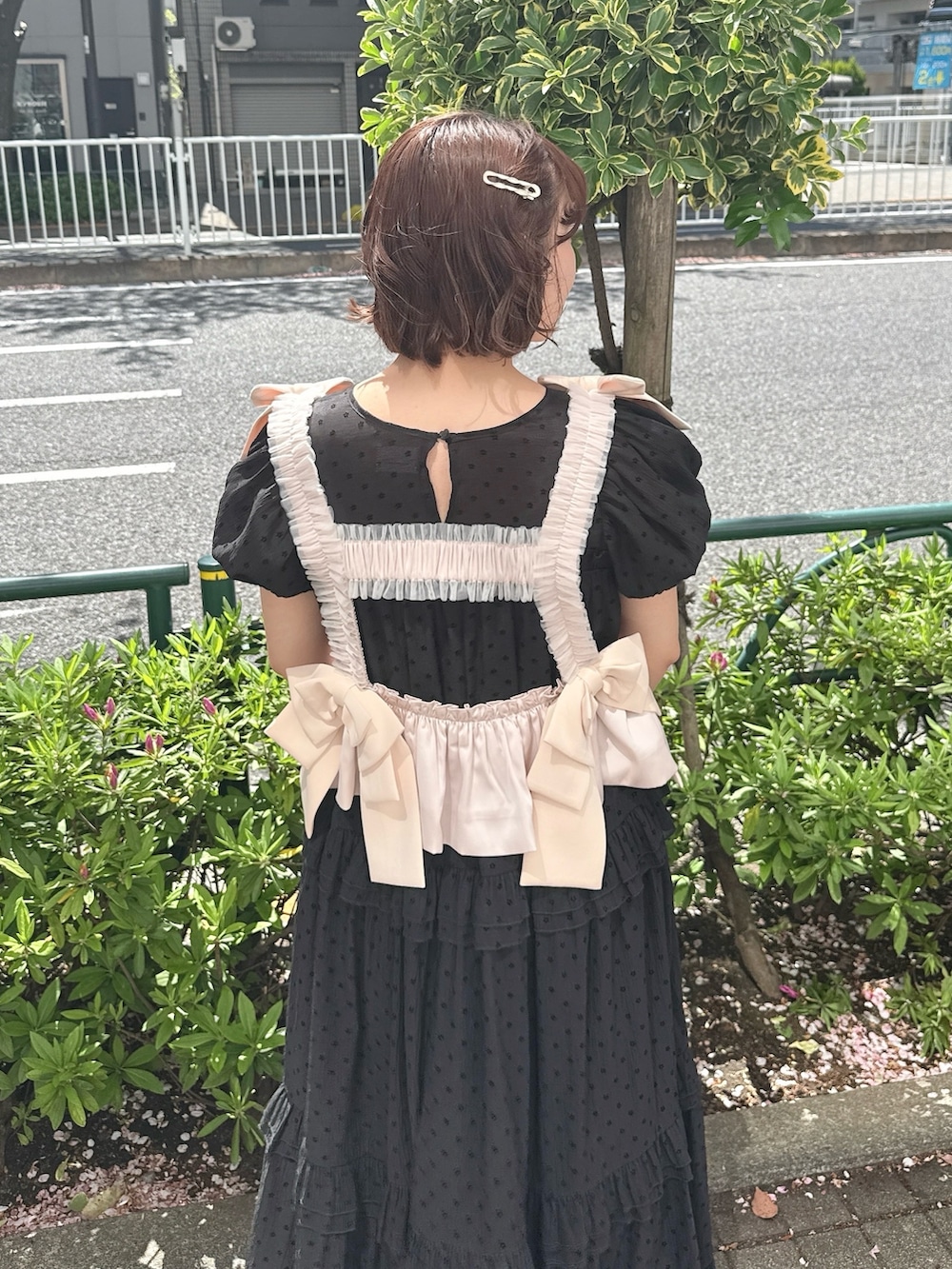 ブラック系のワンピース、ピンク系のハンドバッグ、ブラック系のバレエシューズを着用したレディースの春コーディネートの5枚目の写真