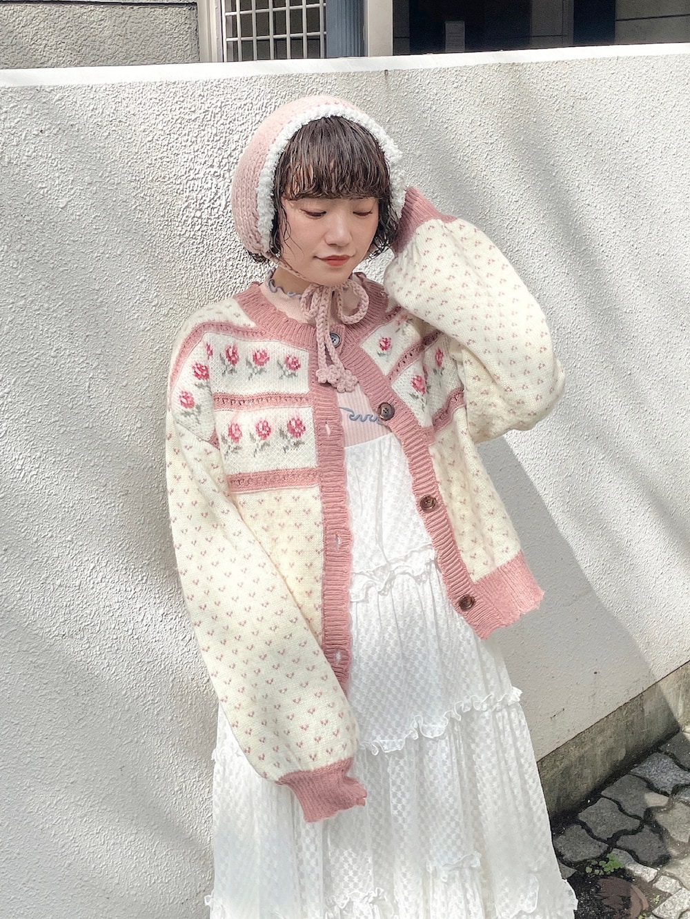 ピンク系のカーディガン/ボレロ、ピンク系のニット/セーター、ホワイト系のワンピースを着用したレディースの秋コーディネートの4枚目の写真