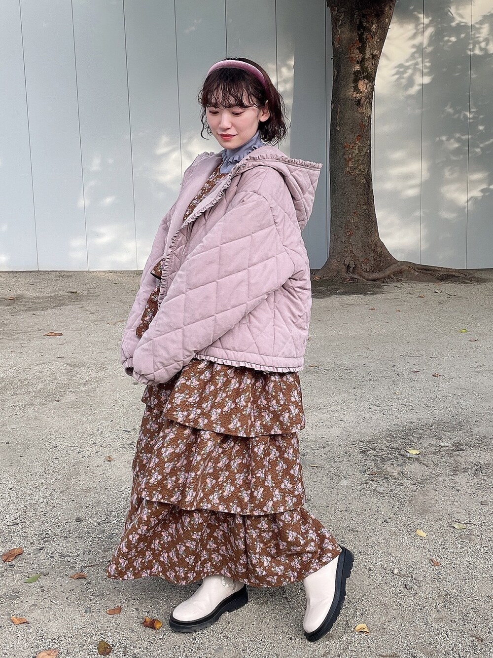 ピンク系のその他アウター、ブラック系のジャンパースカート、ブルー系のニット/セーターを着用したレディースの冬コーディネートの3枚目の写真