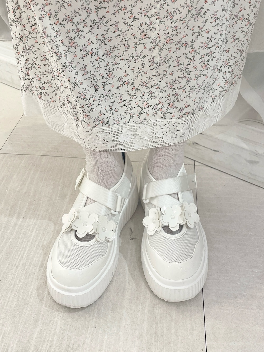 ホワイト系のスカート、グレー系のスウェット、ホワイト系のスニーカーを着用したレディースの冬コーディネートの8枚目の写真