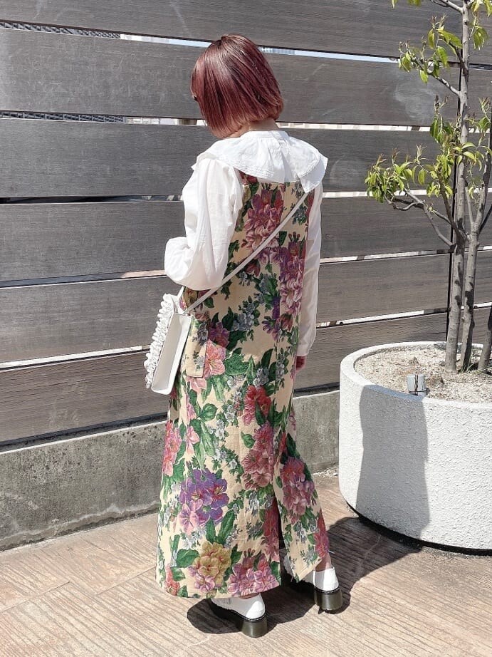 ベージュ系のジャンパースカート、ホワイト系のショルダーバッグ、ホワイト系のシャツ/ブラウスを着用したレディースの春コーディネートの3枚目の写真