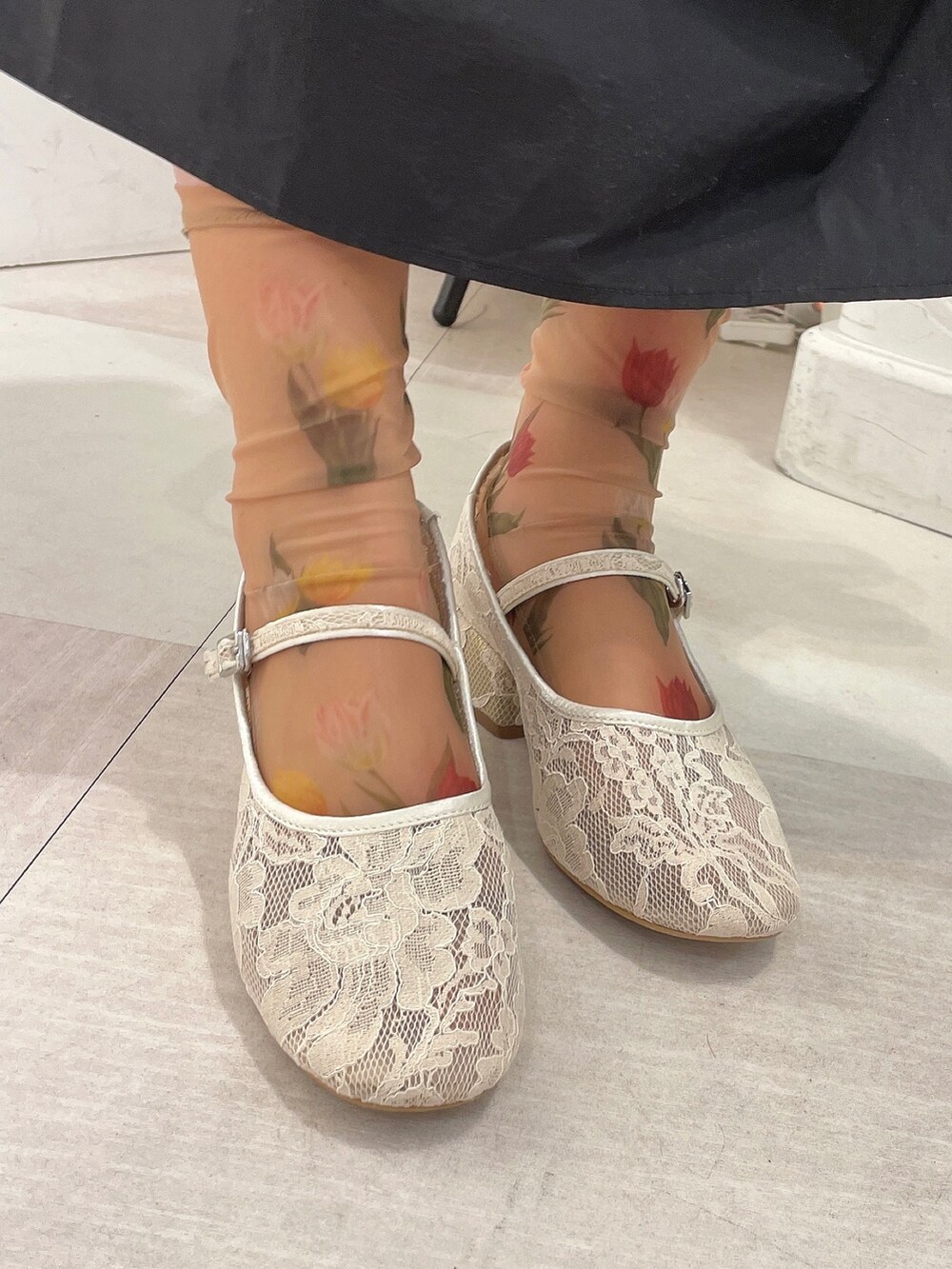 ホワイト系のシャツ/ブラウス、ブラック系のスカート、ホワイト系のパンプスを着用したレディースの春コーディネートの6枚目の写真