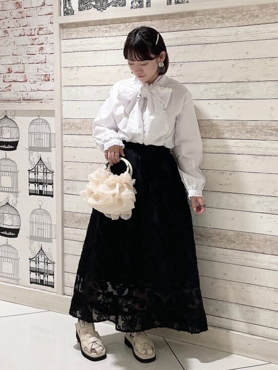 ホワイト系のハンドバッグ、ホワイト系のサンダル、ホワイト系のシャツ/ブラウスを着用したレディースの夏コーディネートの2枚目の写真