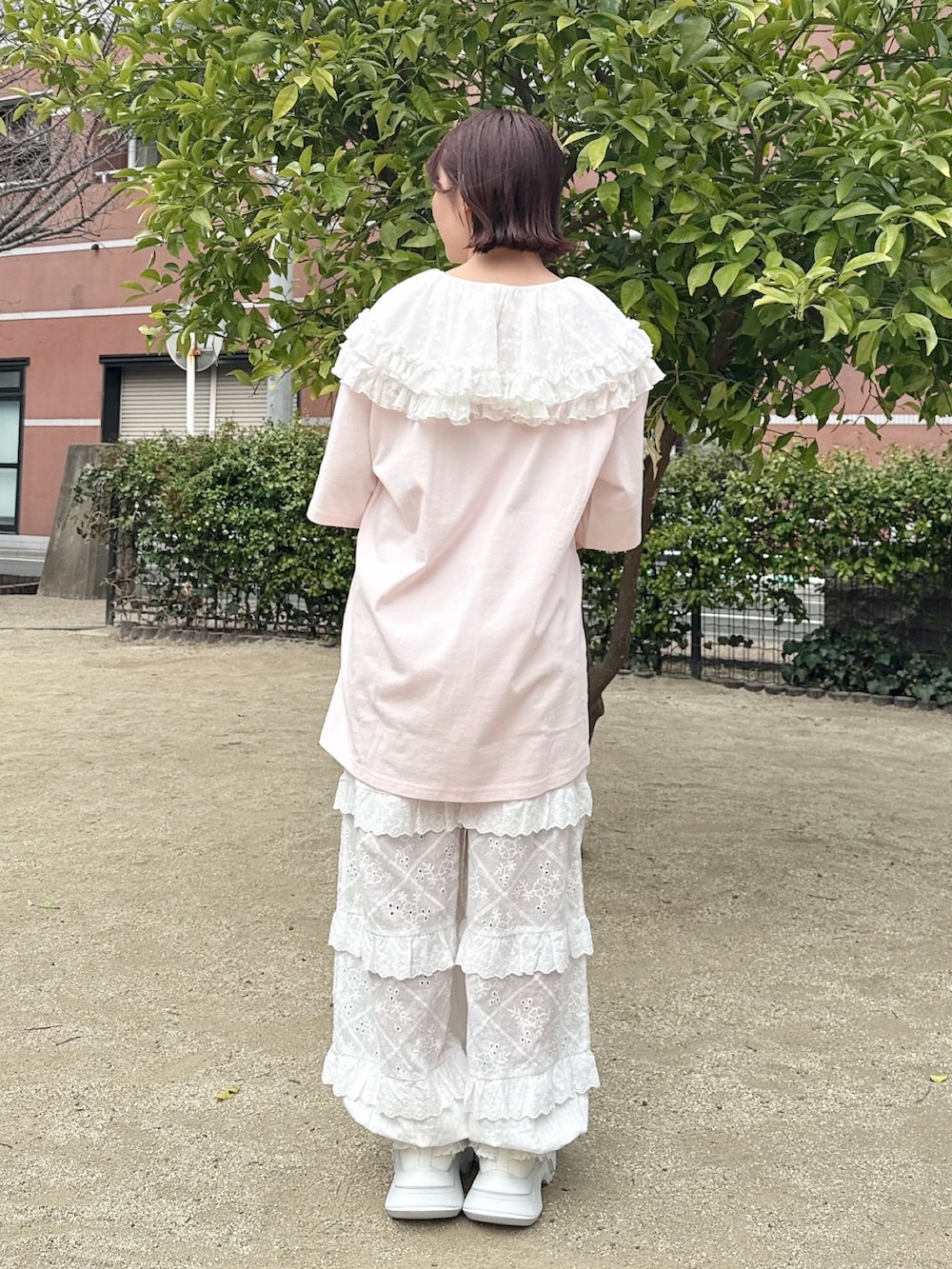 ピンク系のTシャツ/カットソー、ホワイト系のかごバッグ、ホワイト系のスニーカーを着用したレディースの春コーディネートの3枚目の写真