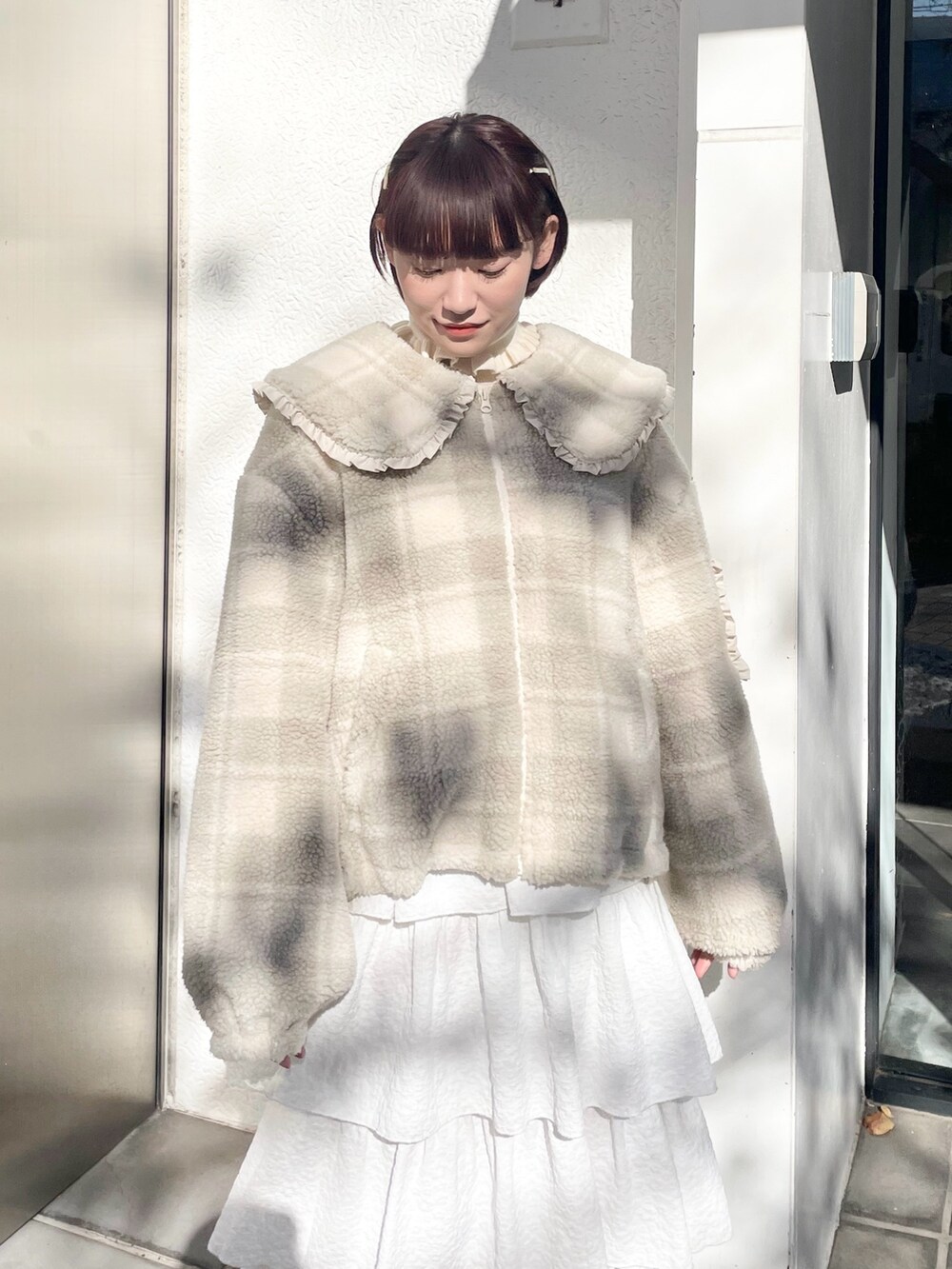 ホワイト系のスカート、ベージュ系のブルゾン、ホワイト系のニット/セーターを着用したレディースの冬コーディネートの5枚目の写真