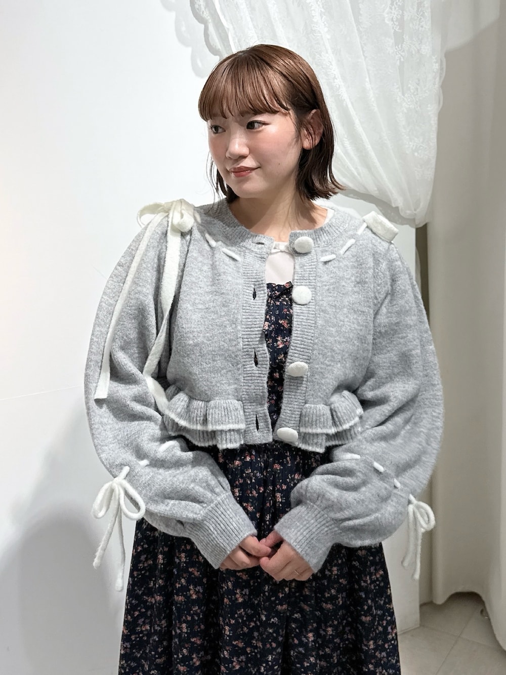 グレー系のカーディガン/ボレロ、ホワイト系のTシャツ/カットソー、ホワイト系のショルダーバッグを着用したレディースの秋コーディネートの6枚目の写真