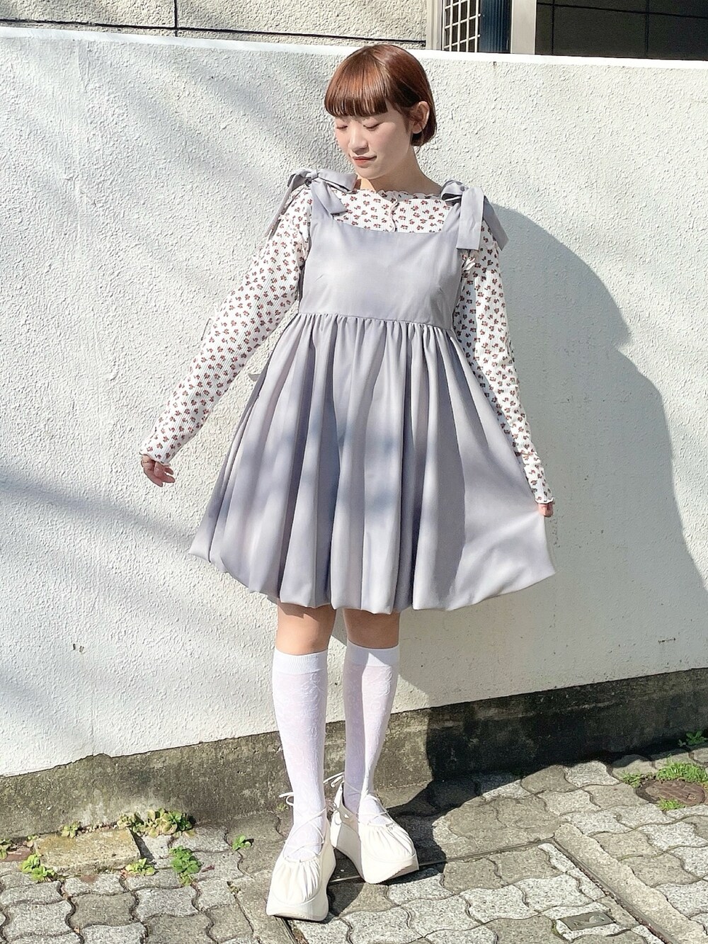 ピンク系のTシャツ/カットソー、グレー系のワンピース、ホワイト系のバレエシューズを着用したレディースの冬コーディネートの2枚目の写真