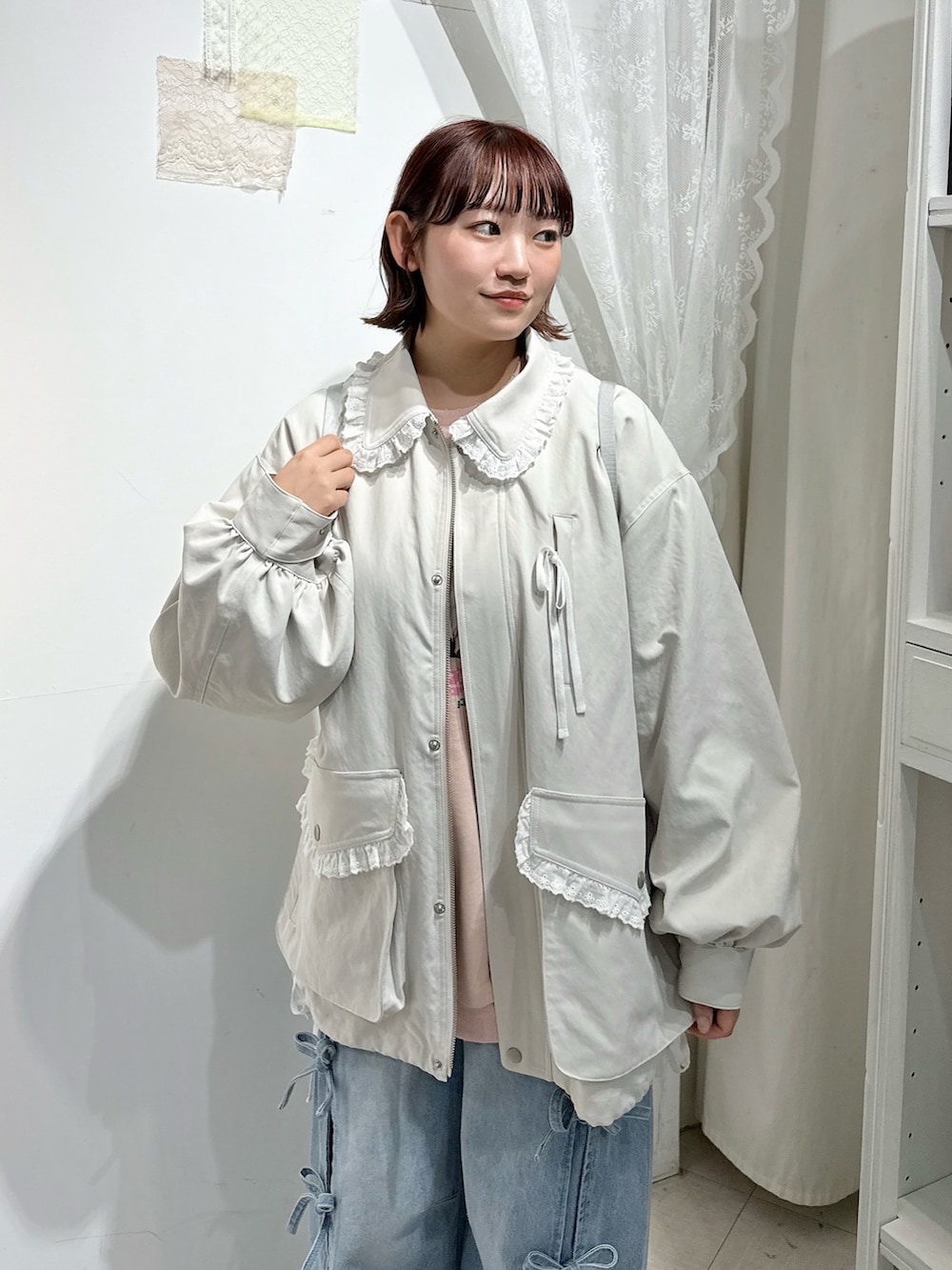 ホワイト系のブルゾン、ホワイト系のバックパック/リュック、ブルー系のデニムパンツを着用したレディースの冬コーディネートの5枚目の写真