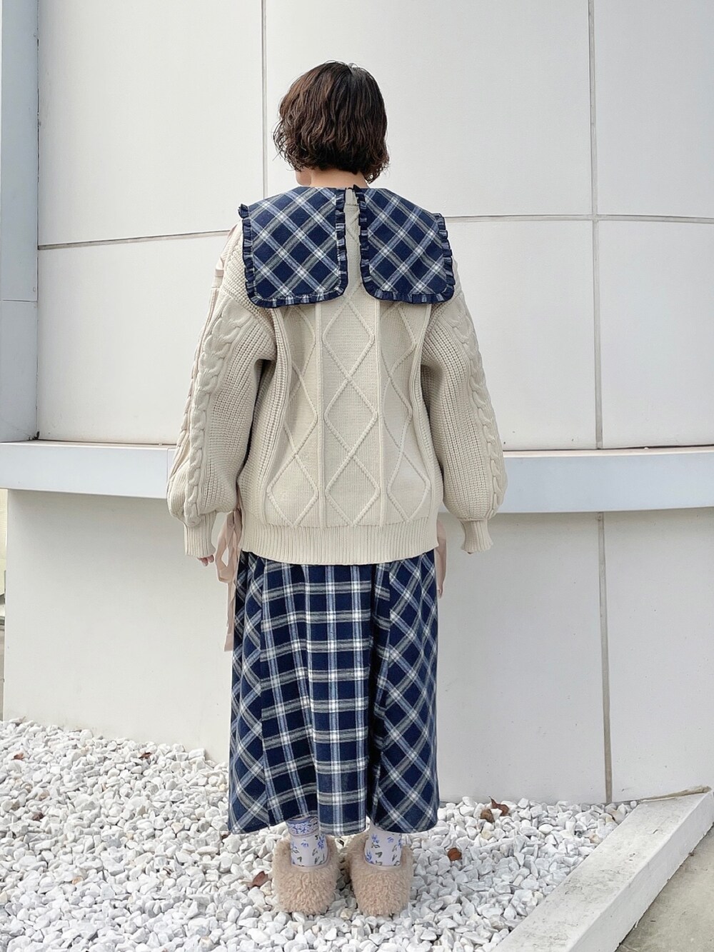 ブルー系のワンピース、ホワイト系のニット/セーター、ベージュ系のスリッポンを着用したレディースの秋コーディネートの3枚目の写真