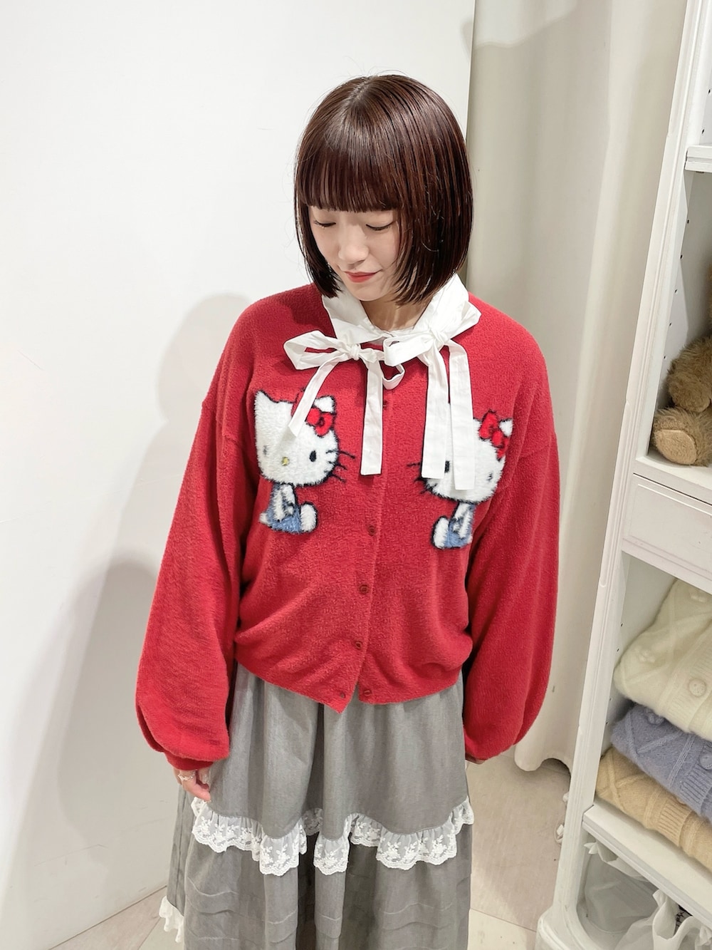 ホワイト系のシャツ/ブラウス、レッド系のカーディガン/ボレロ、グレー系のスカートを着用したレディースの秋コーディネートの4枚目の写真