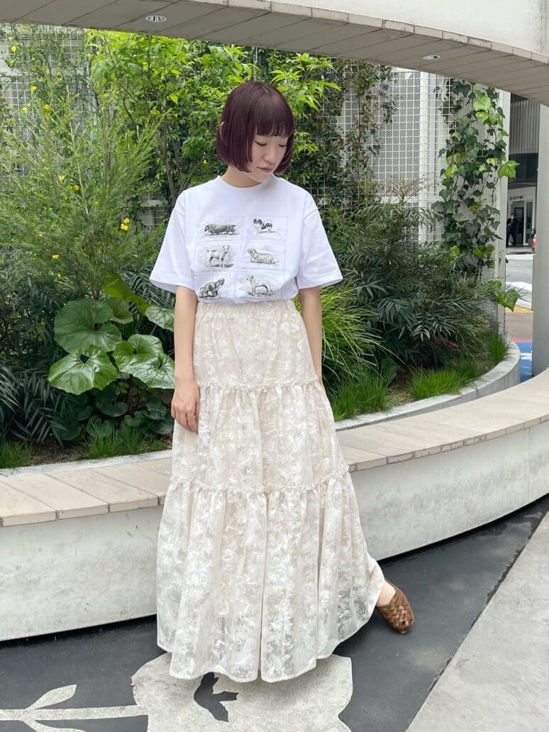 ベージュ系のスカート、ホワイト系のTシャツ/カットソー、ベージュ系のパンプスを着用したレディースの春コーディネートの5枚目の写真