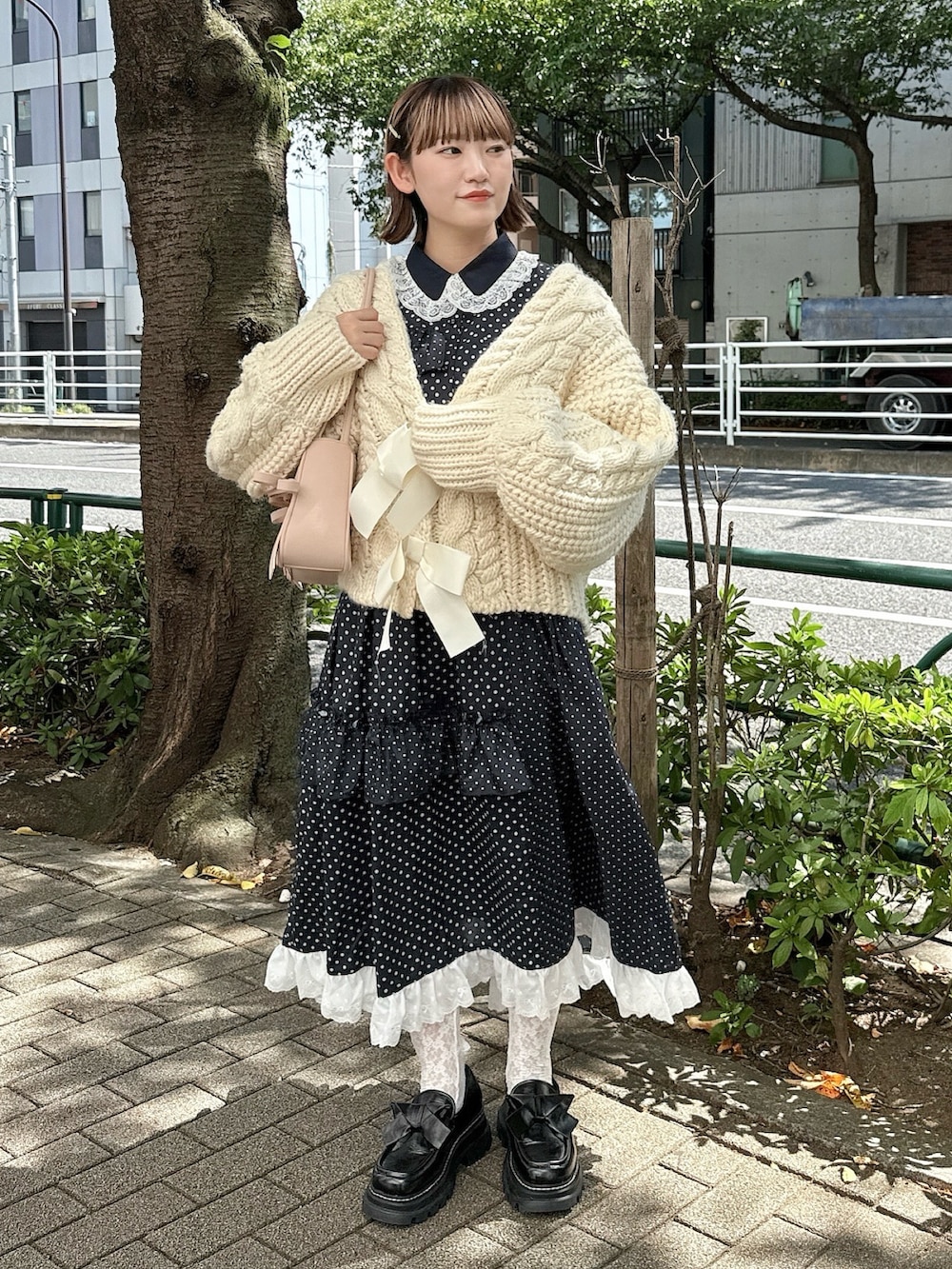 ホワイト系のカーディガン/ボレロ、ピンク系のハンドバッグ、ブラック系のローファーを着用したレディースの秋コーディネートの2枚目の写真