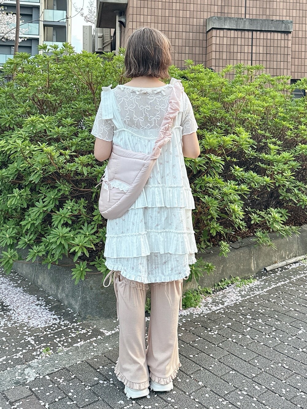 ピンク系のショルダーバッグ、ホワイト系のTシャツ/カットソー、ピンク系のワンピースを着用したレディースの春コーディネートの3枚目の写真